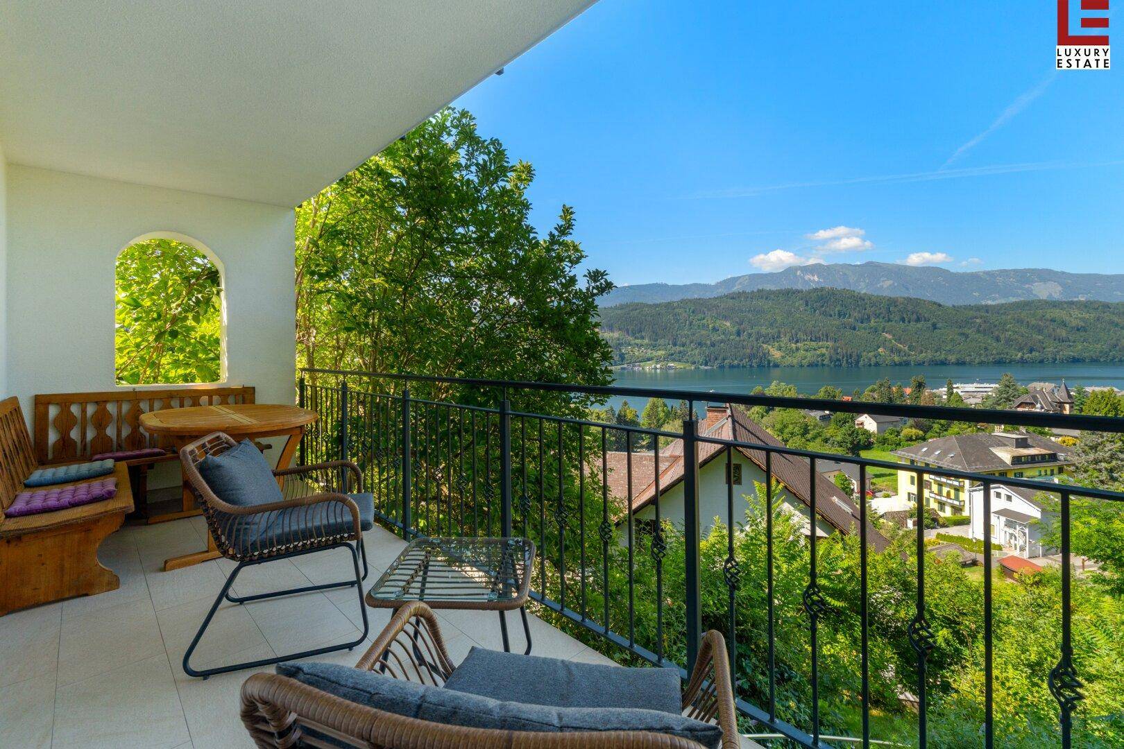 Geräumiger Balkon mit Sitzgelegenheiten und atemberaubendem Blick auf den See und die Berglandschaft.