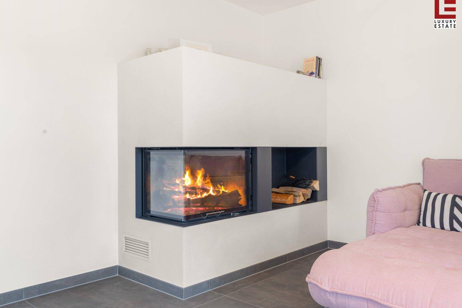 Gemütlicher Wohnbereich mit modernem Kamin und großformatigen Fliesen, ideal für kalte Abende.