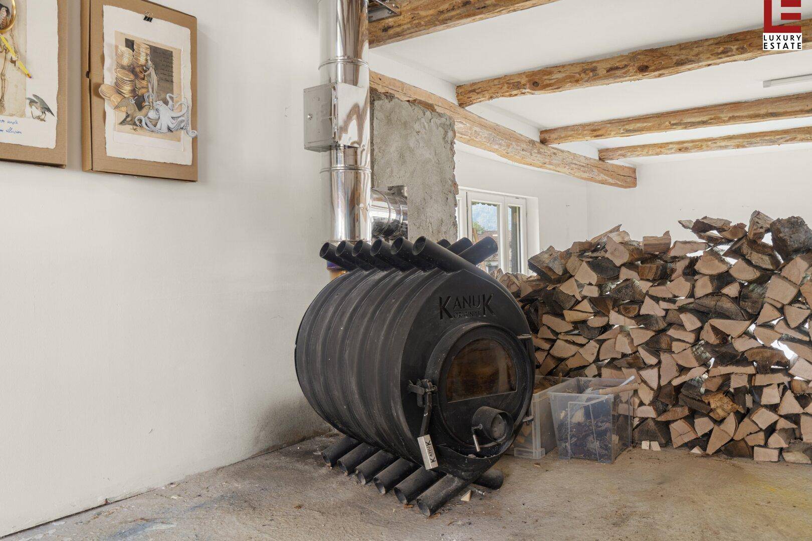 Rustikaler Holzofen mit großem Brennholzstapel, der Wärme und Gemütlichkeit verspricht.