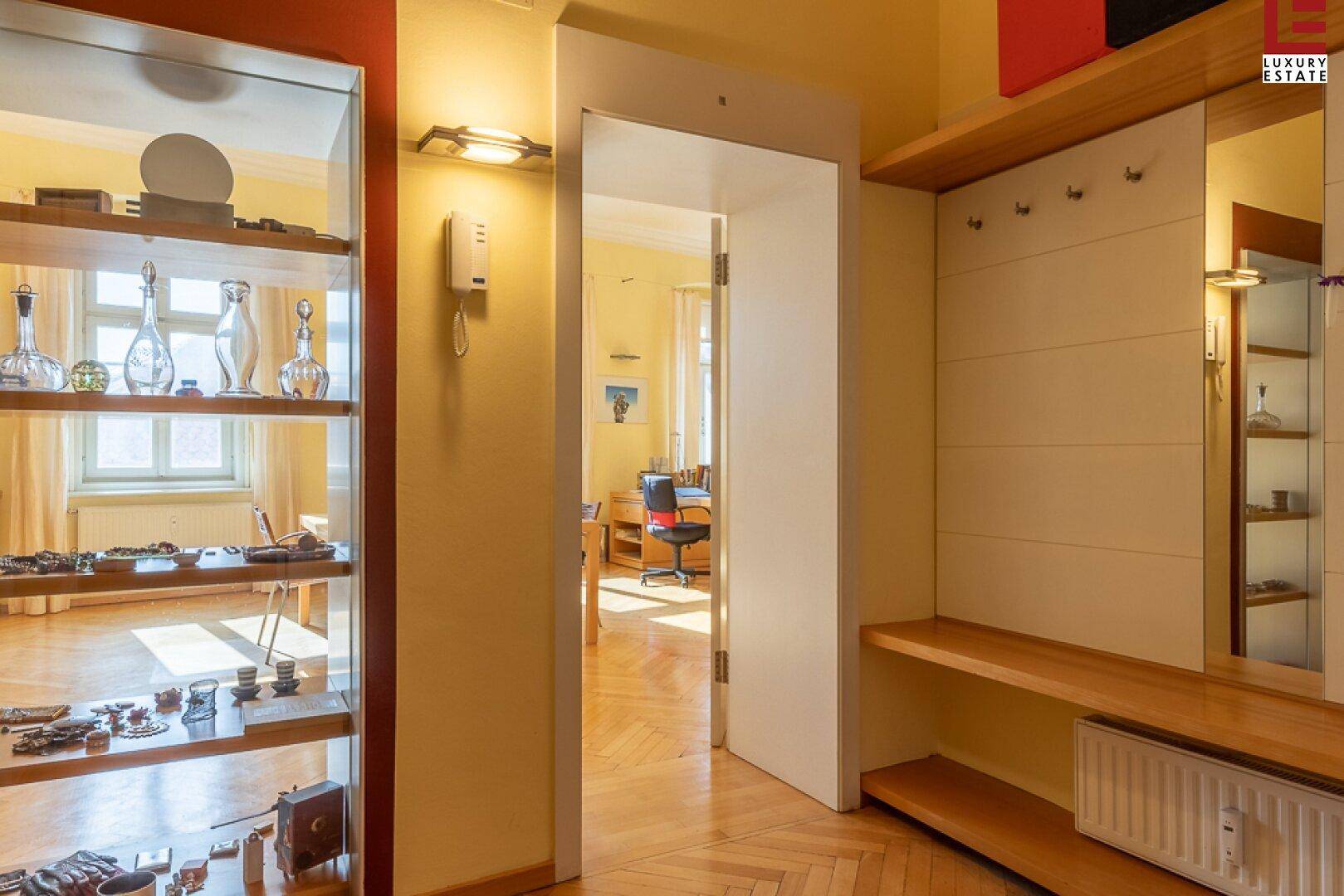 Heller Flur mit Garderobe, Spiegel und Blick in angrenzende Räume.