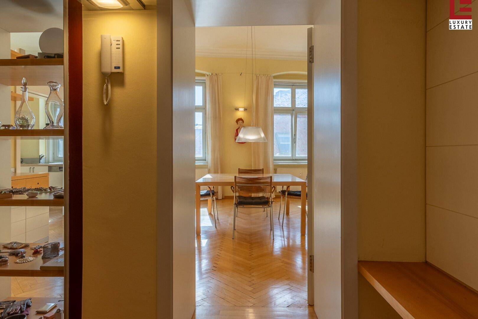Flur mit Blick in den hellen Essbereich mit Fischgrätparkett.