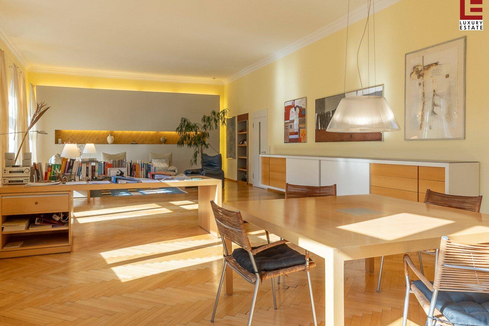 Großzügiger Wohn-Essbereich mit Arbeitsplatz, Parkettboden und viel Tageslicht.