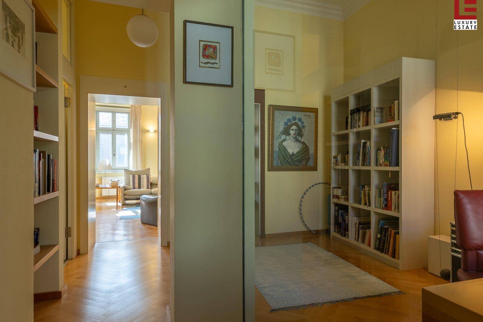 Heller Flur mit Bücherregalen und Blick in einen angrenzenden Raum.