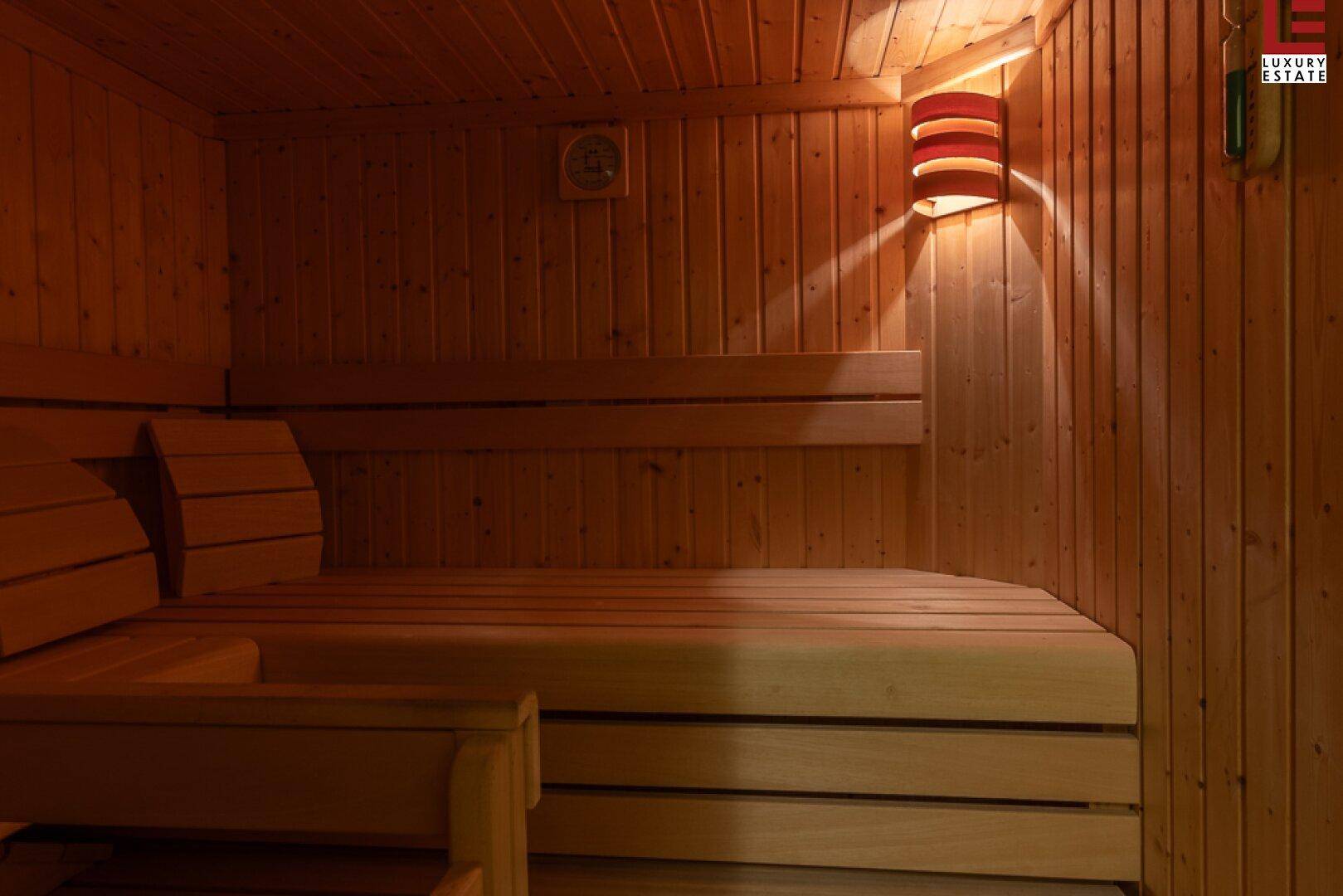 Gemütliche Holzsauna mit Bänken und stimmungsvoller Beleuchtung für Entspannung.