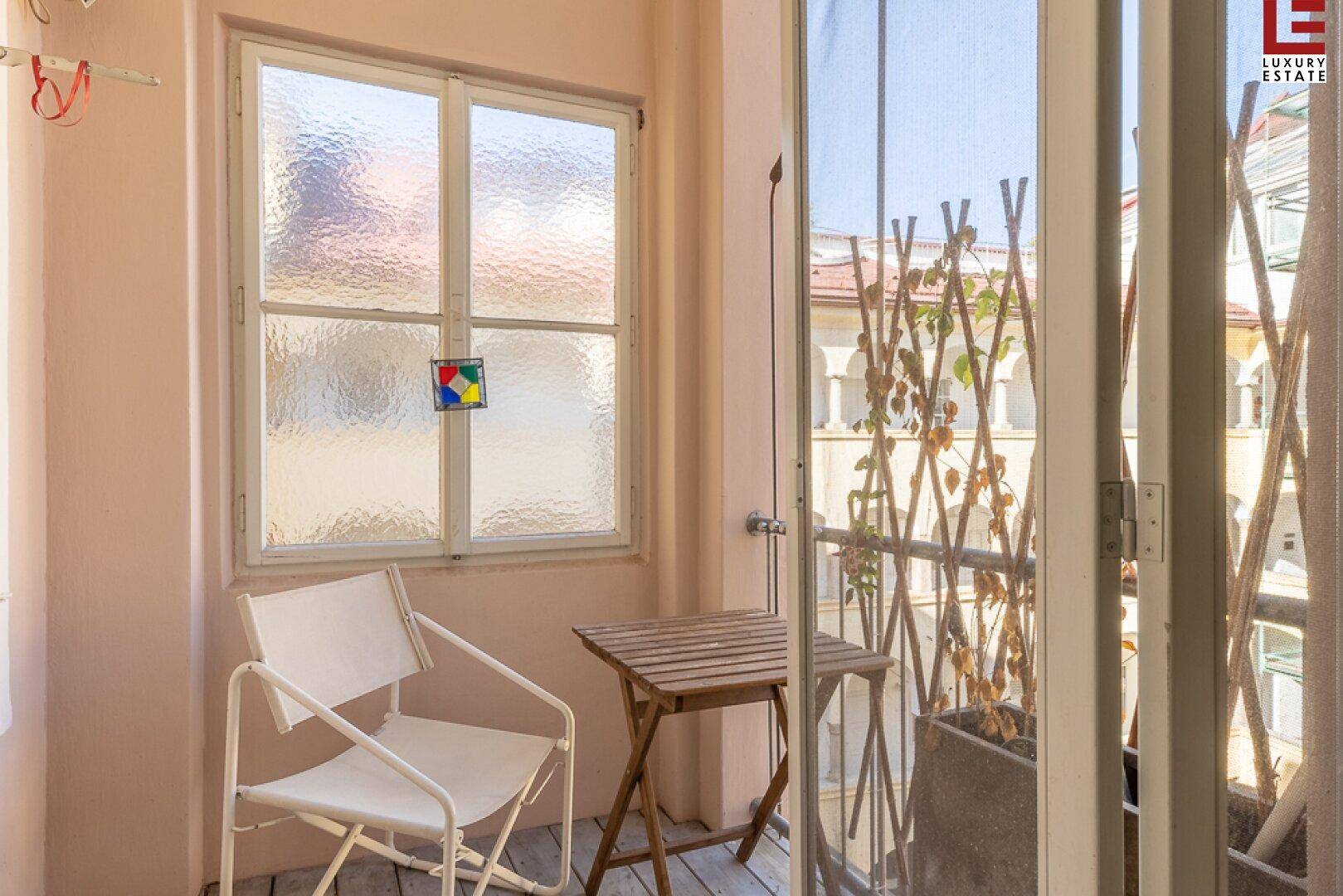 Kleiner, gemütlicher Balkon mit Sitzgelegenheit und Blick auf die umliegenden Gebäude.