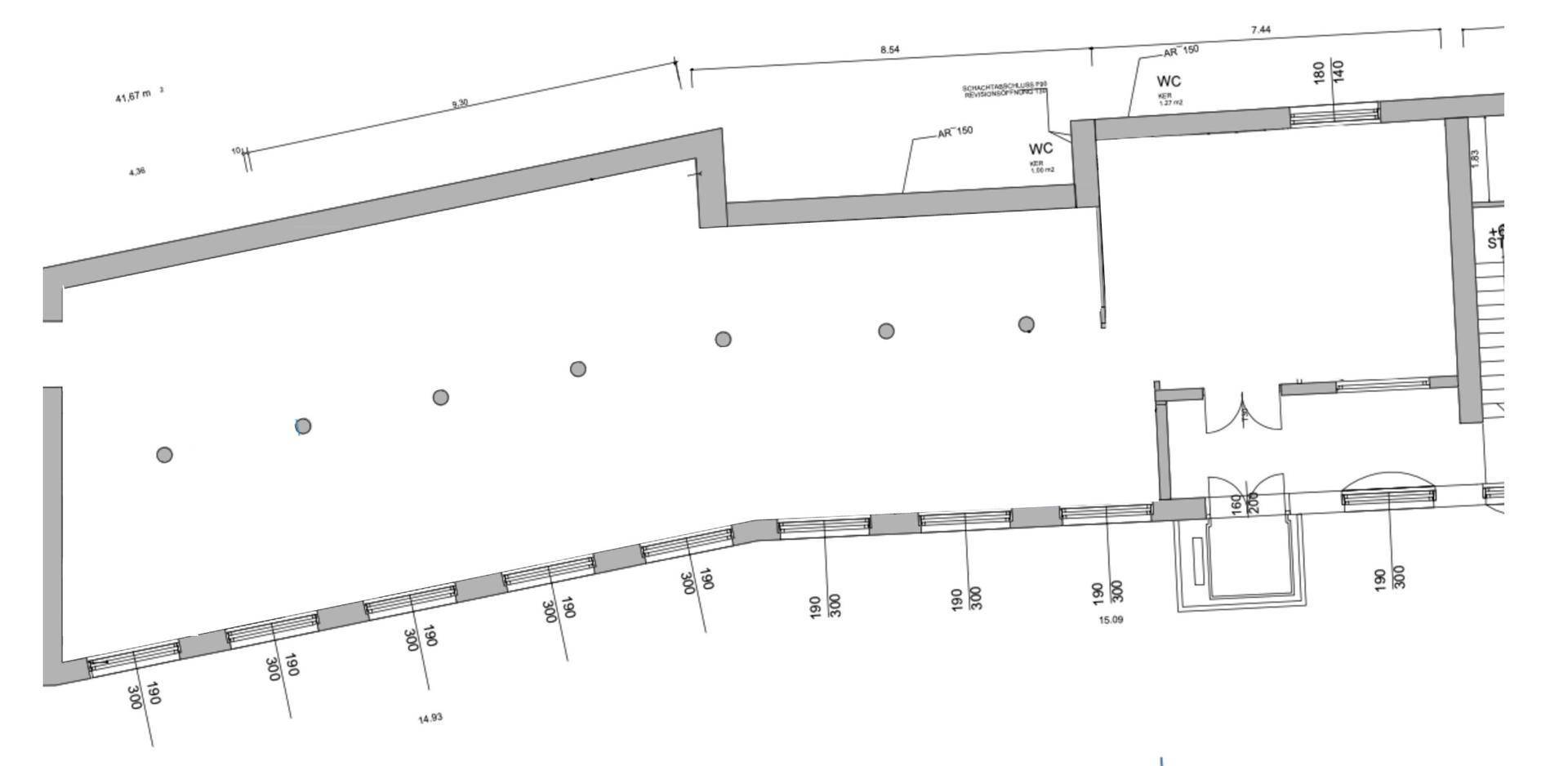 Grundriss eines leeren Bürogeschosses mit Sanitärbereichen, Säulen und großen Fensterfronten.