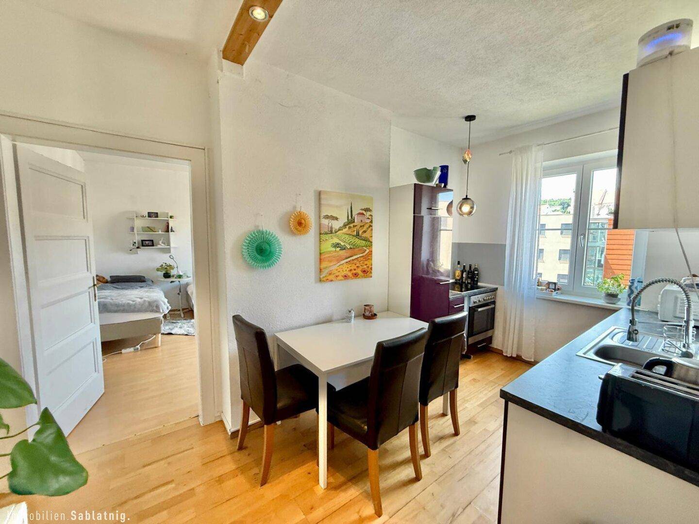 Essbereich in der Küche mit Blick durch die offene Tür in ein weiteres Zimmer.