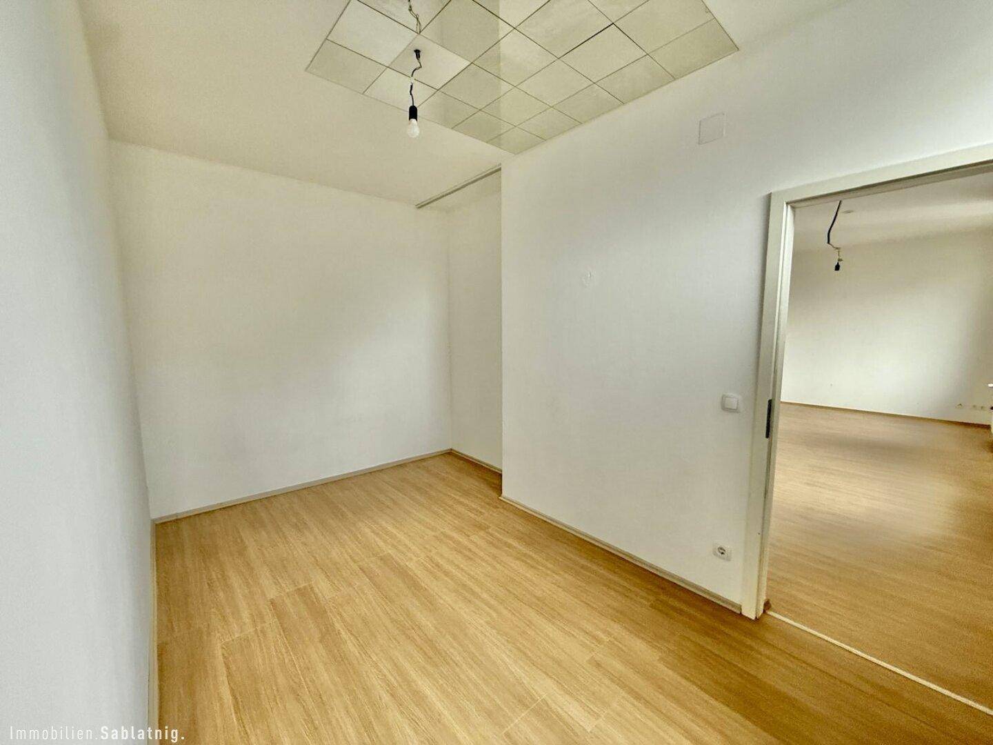 Leerer Raum mit Holzfußboden und weiß gestrichenen Wänden, ideal für verschiedene Nutzungen.