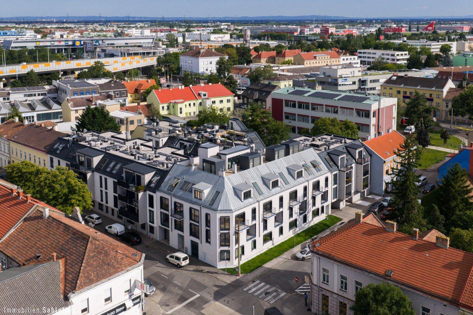 Weitläufige Luftaufnahme eines modernen Wohnkomplexes in einer städtischen Umgebung.