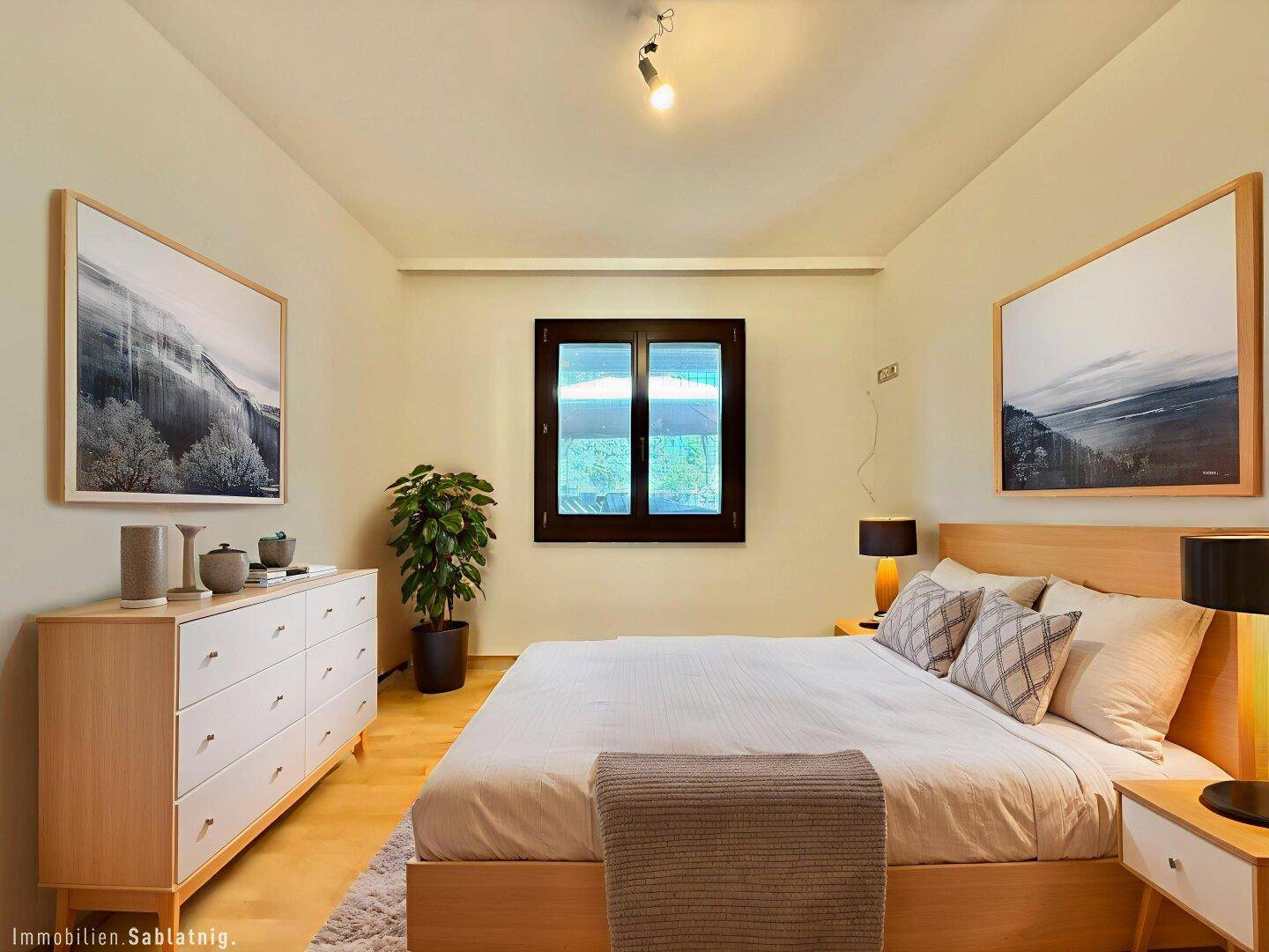 Modern eingerichtetes Schlafzimmer mit Holzbett, Kommode und hellem Parkettboden.