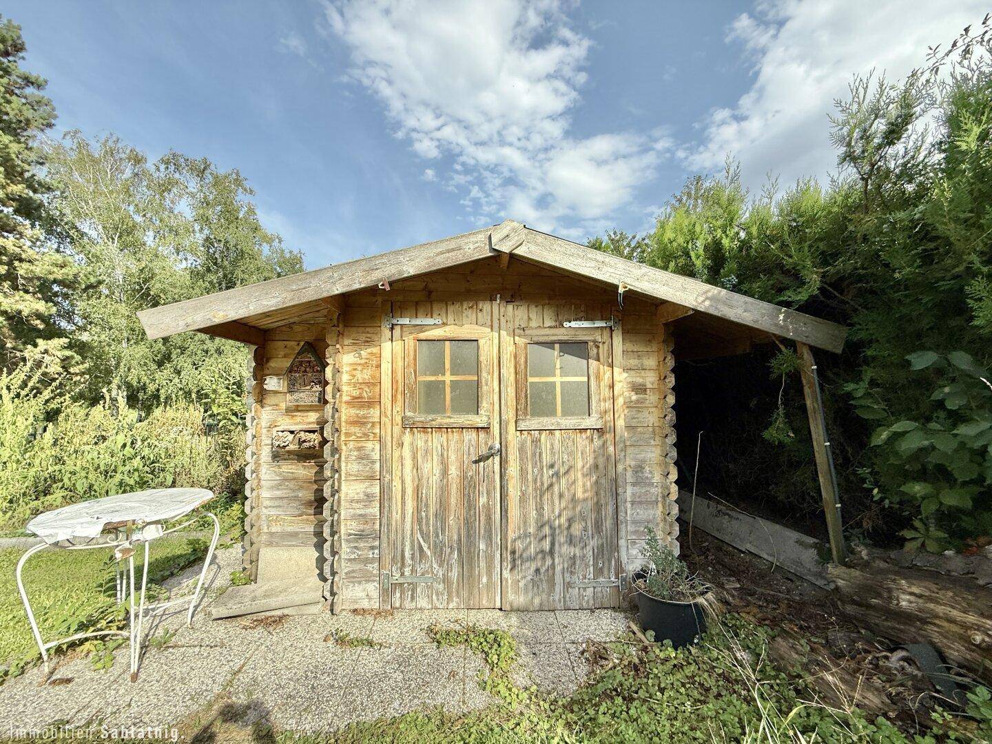 Rustikaler Holzschuppen im Garten, ideal zur Aufbewahrung von Gartengeräten.