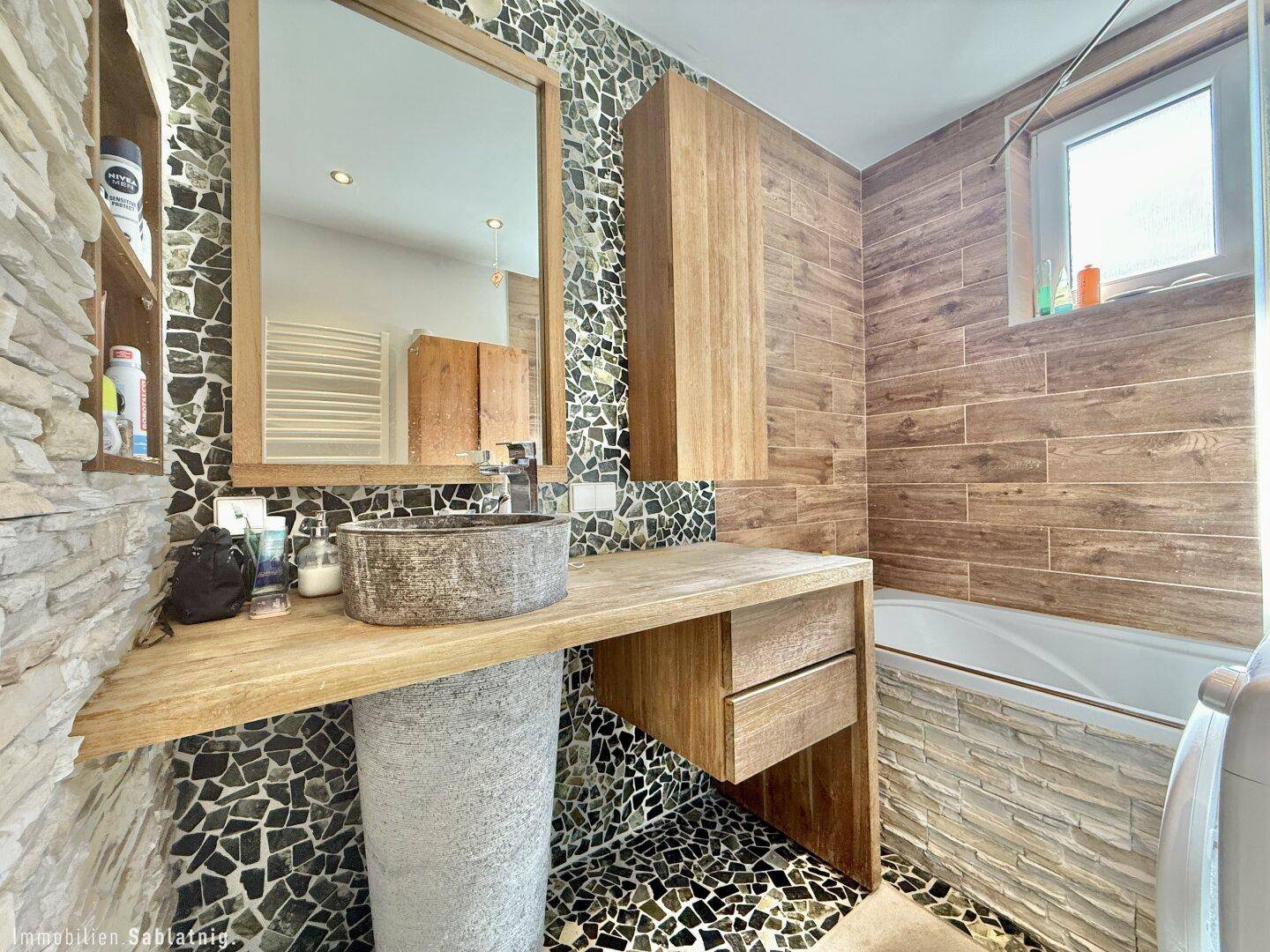 Modernes Badezimmer mit einzigartigem Waschbecken, Spiegel und Badewanne.