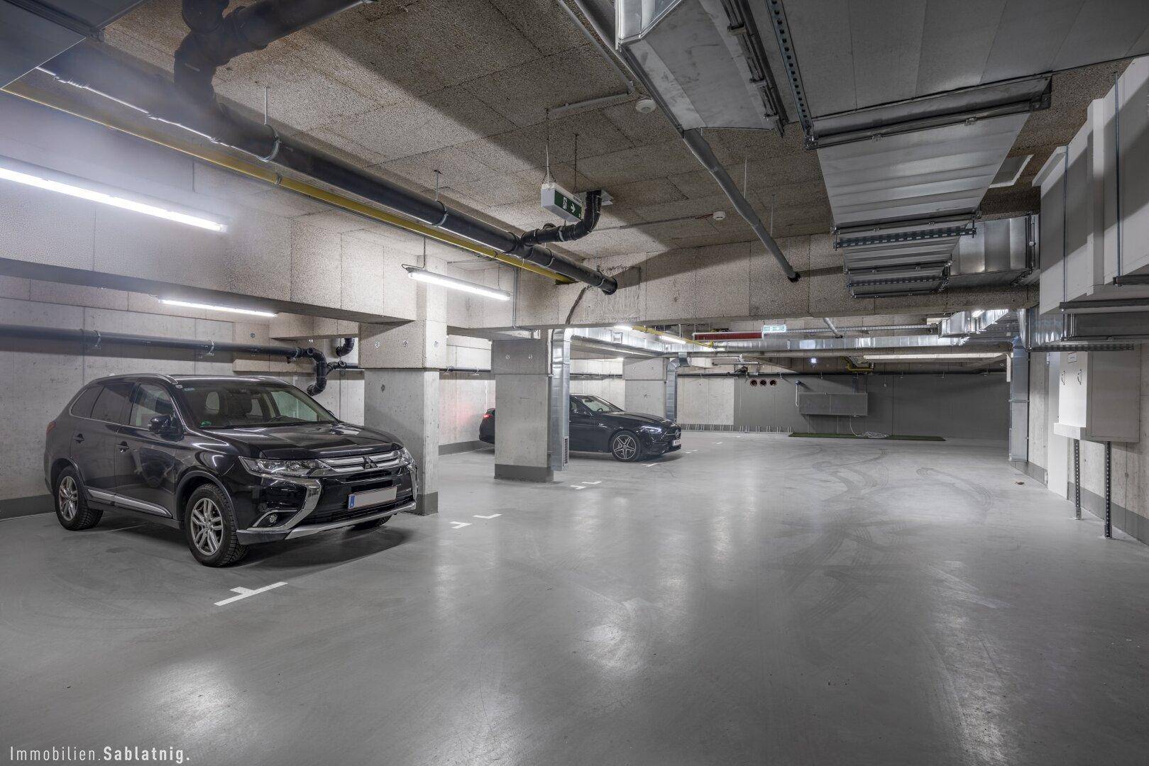 Tiefgarage mit mehreren Stellplätzen und moderner Beleuchtung, gut beleuchtet und sauber.