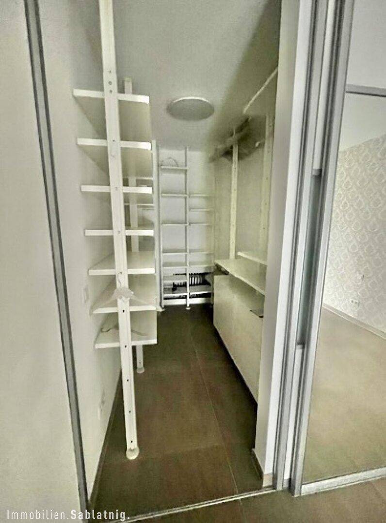 Praktischer begehbarer Kleiderschrank mit Regalsystemen und viel Stauraum.