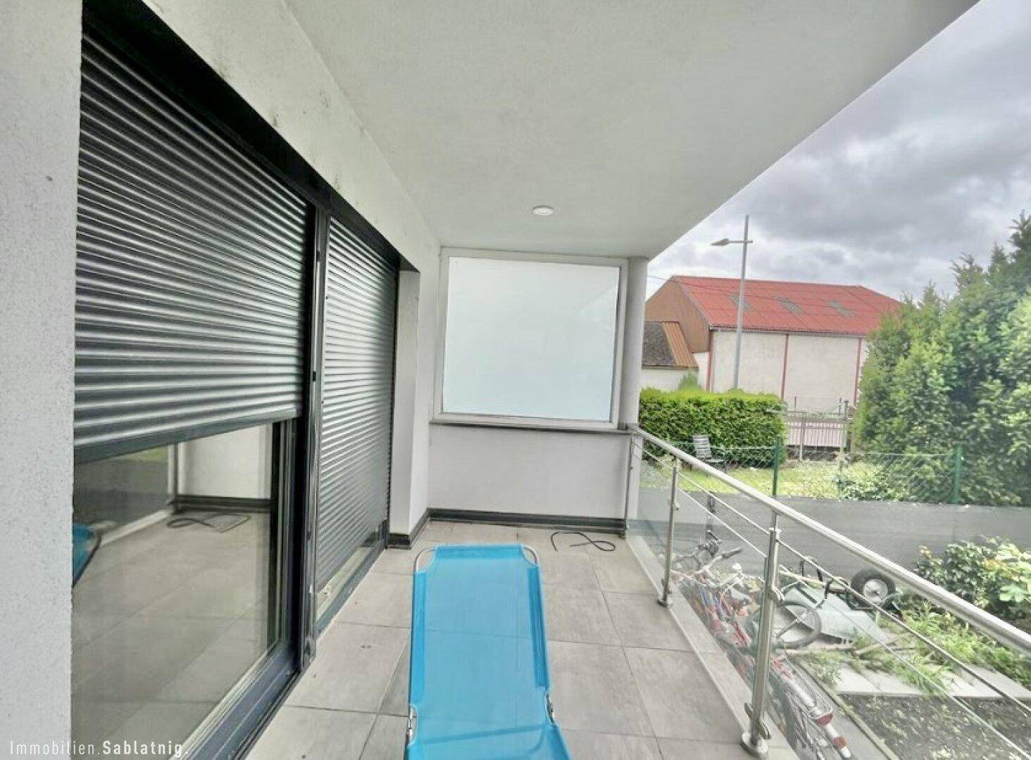 Balkon mit Fliesenboden und Glasgeländer, ideal für entspannte Stunden im Freien.