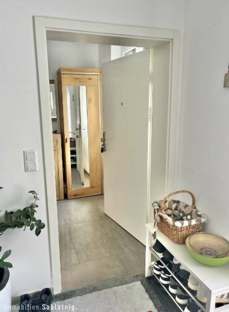 Eingangsbereich mit Schuhregal und Garderobe, führt in den Wohnbereich.