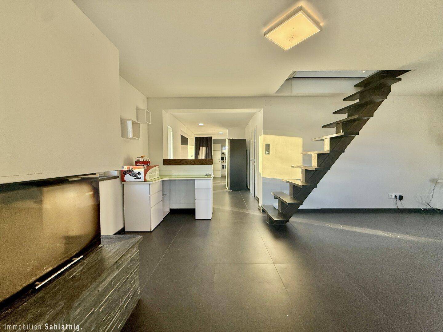 Offener Wohnbereich mit Treppe, viel Platz und modernem Ambiente.