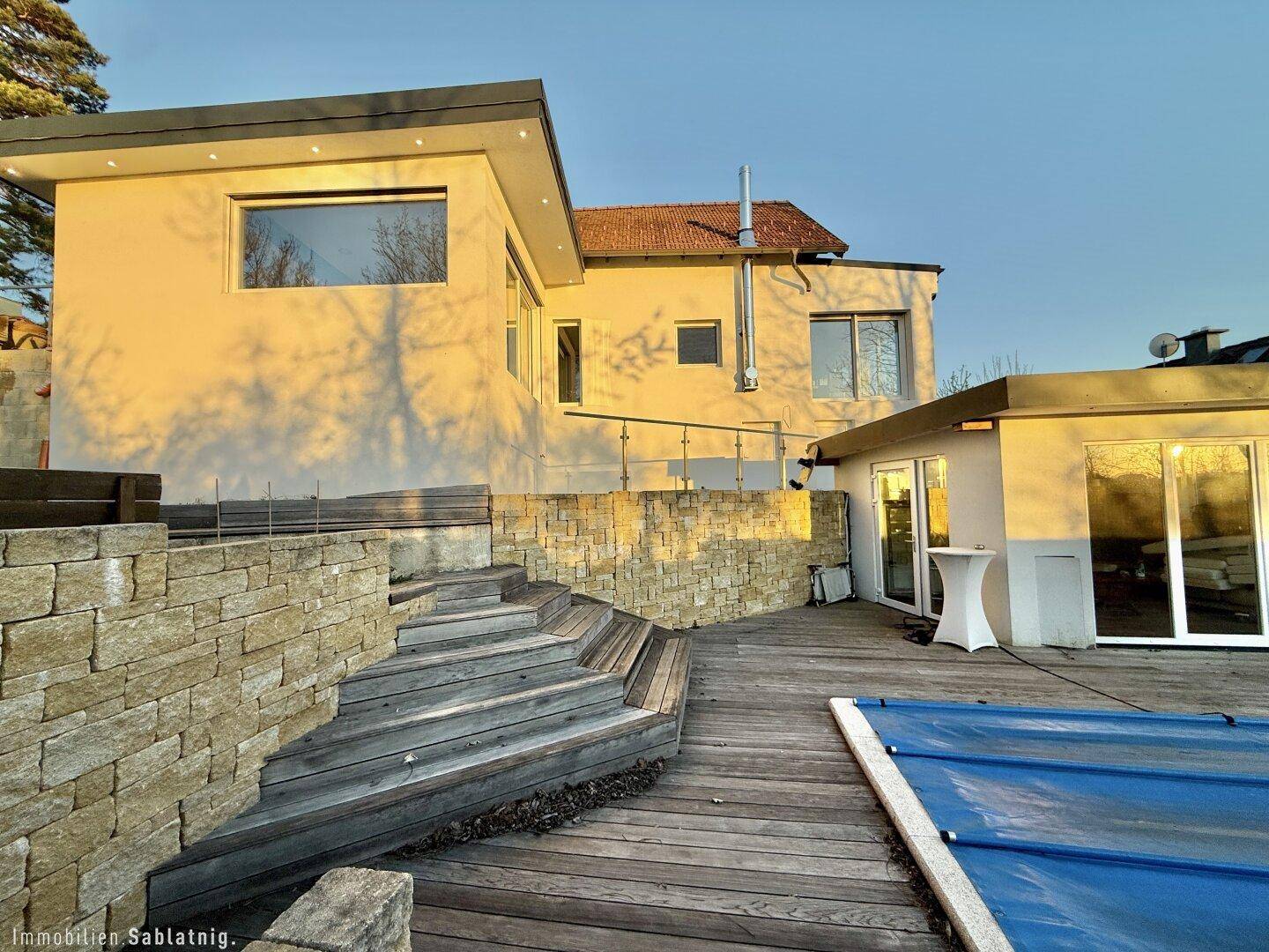 Moderne Architektur des Hauses mit Terrassenbereich und Natursteinmauern.