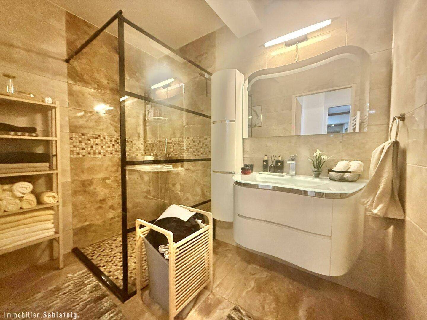 Stilvolles Badezimmer mit moderner Dusche, Doppelwaschbecken und großem Spiegel.
