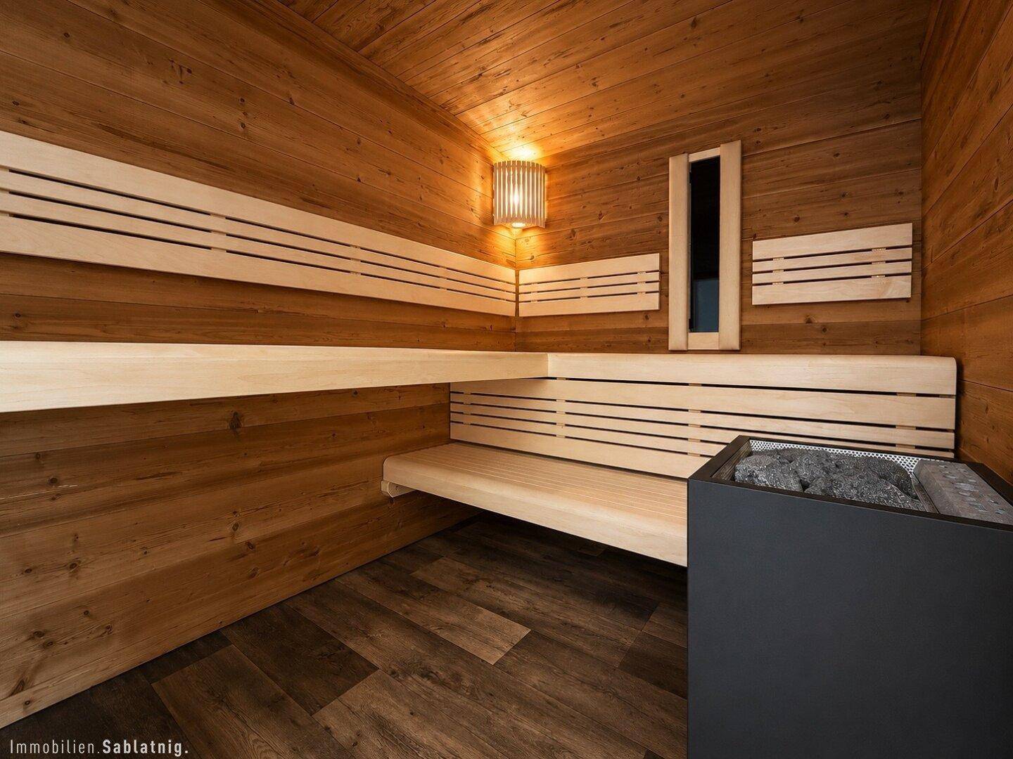 Gemütliche Holzsauna mit Bänken und Saunaofen für Entspannung.