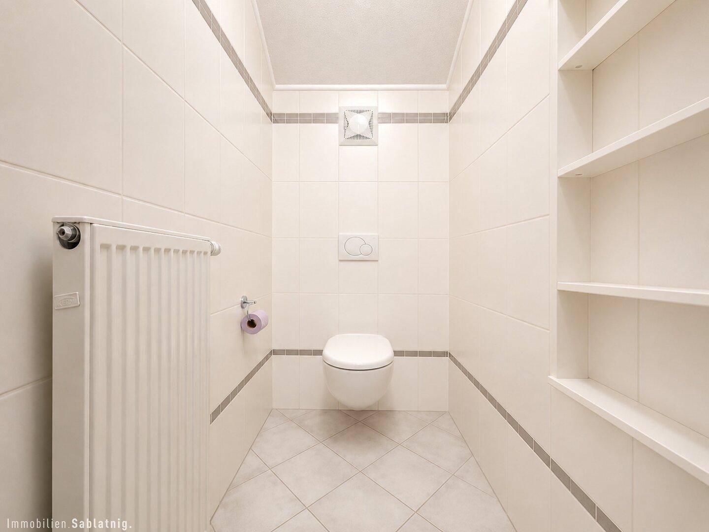 Modernes Gäste-WC mit wandhängender Toilette und weißen Fliesen.