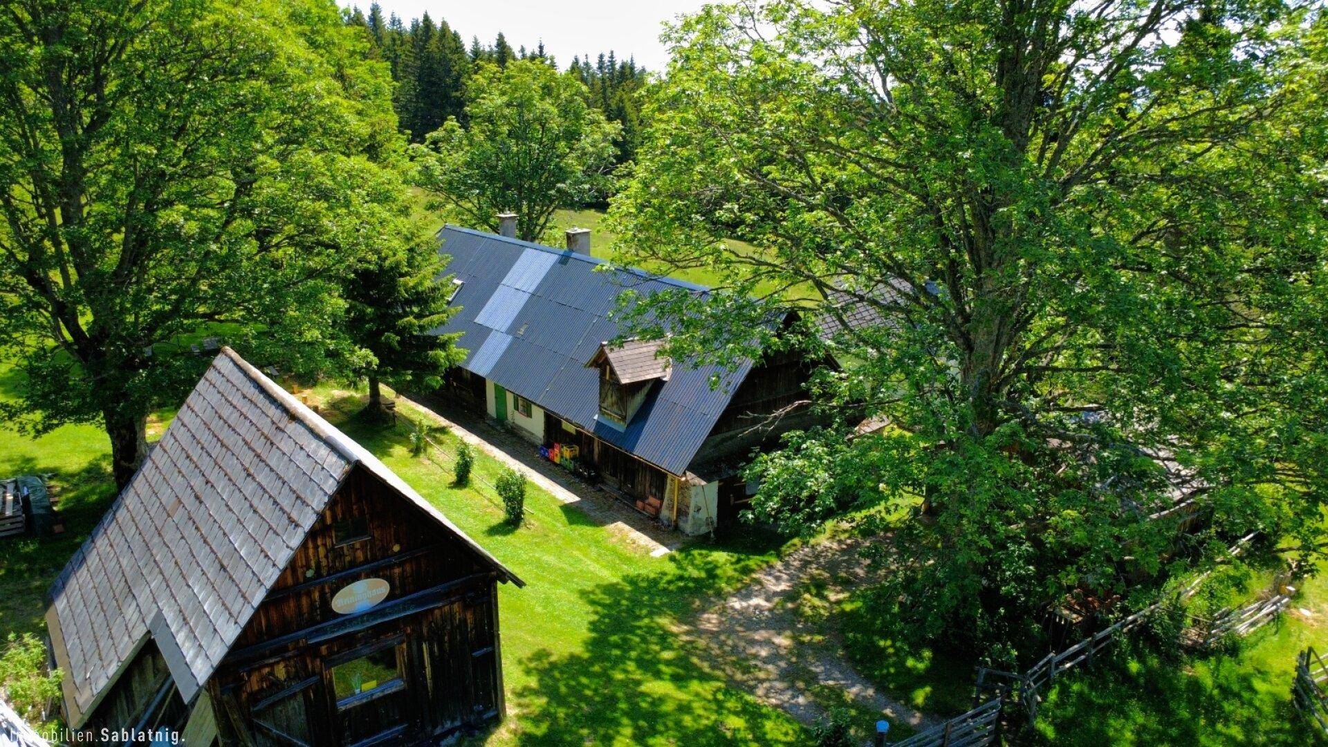 Weitwinkel-Luftaufnahme des Anwesens mit Zufahrtsweg, Haupthaus und Nebengebäude in ländlicher Umgebung.