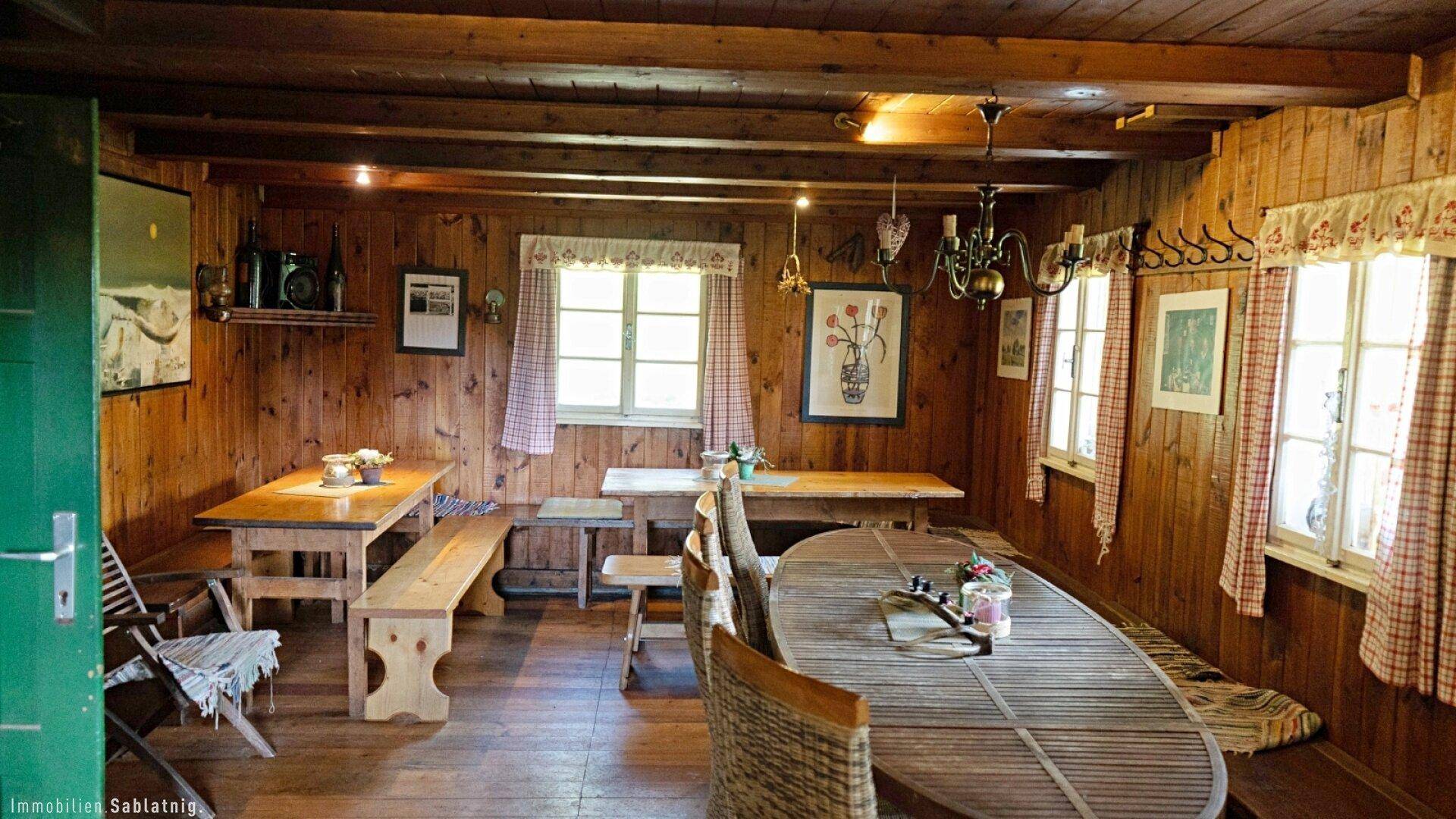 Rustikaler Wohn- und Essbereich mit Holzböden und -wänden, ausgestattet mit traditionellen Möbeln.