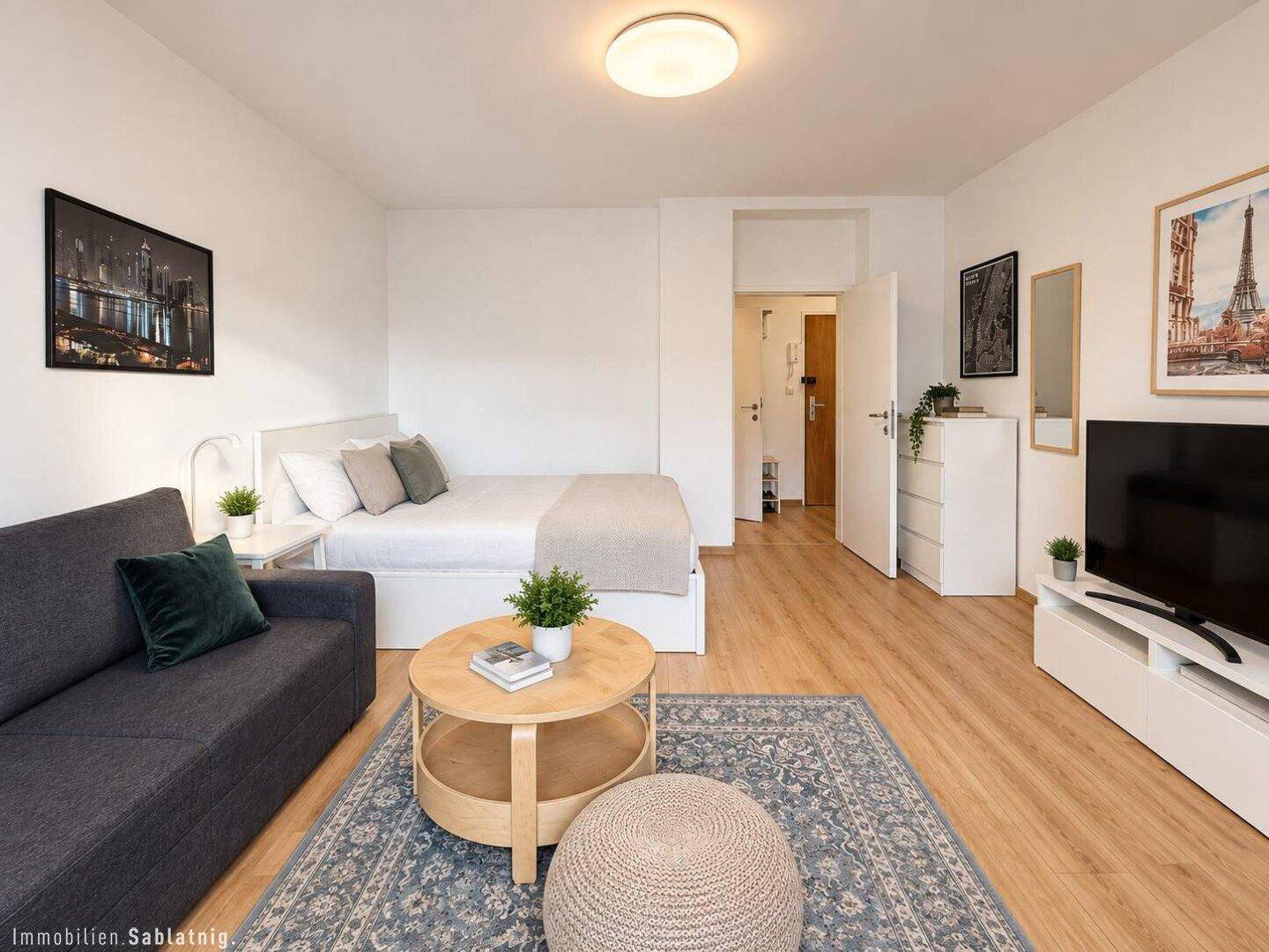 Helles Studio-Apartment mit Schlaf- und Wohnbereich, modern eingerichtet und Parkettboden.