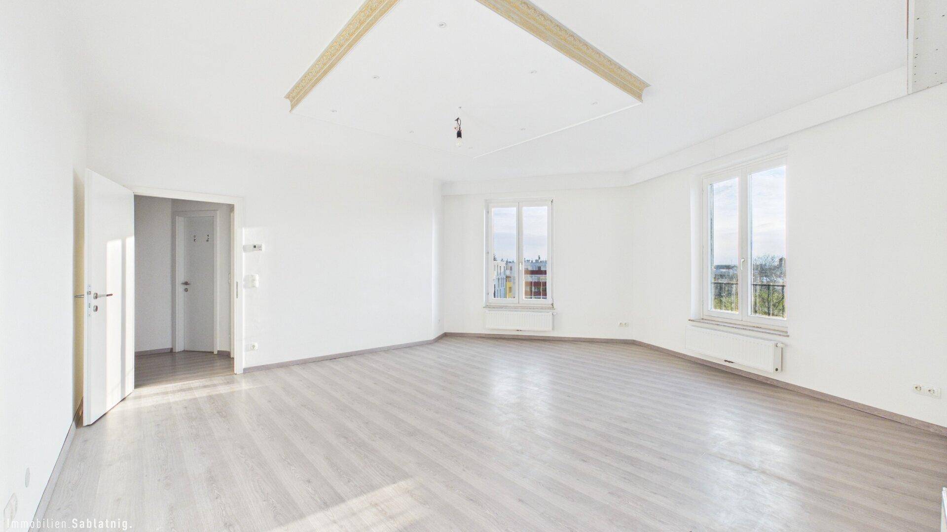 Großes, helles Zimmer mit Laminatboden und mehreren Fenstern, bietet viel Gestaltungsfreiheit.