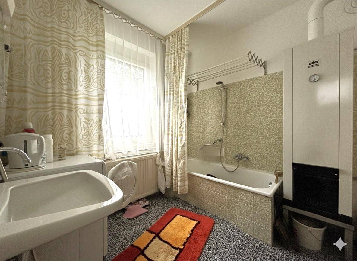 Badezimmer mit Badewanne, Fenster und Waschbecken in traditionellem Stil.