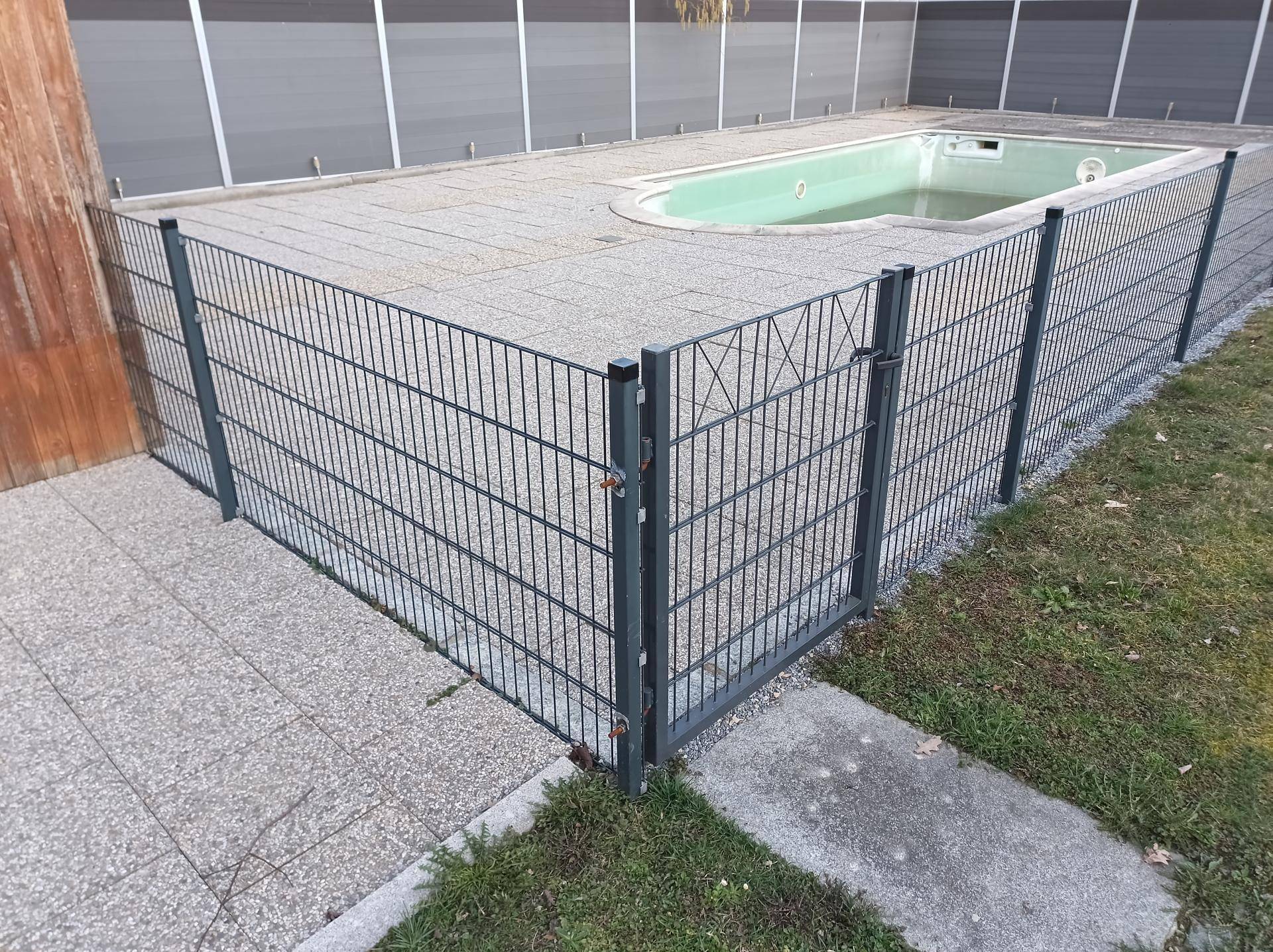 Eingezäunter Poolbereich im Garten, bereit für die Renovierung oder Befüllung.