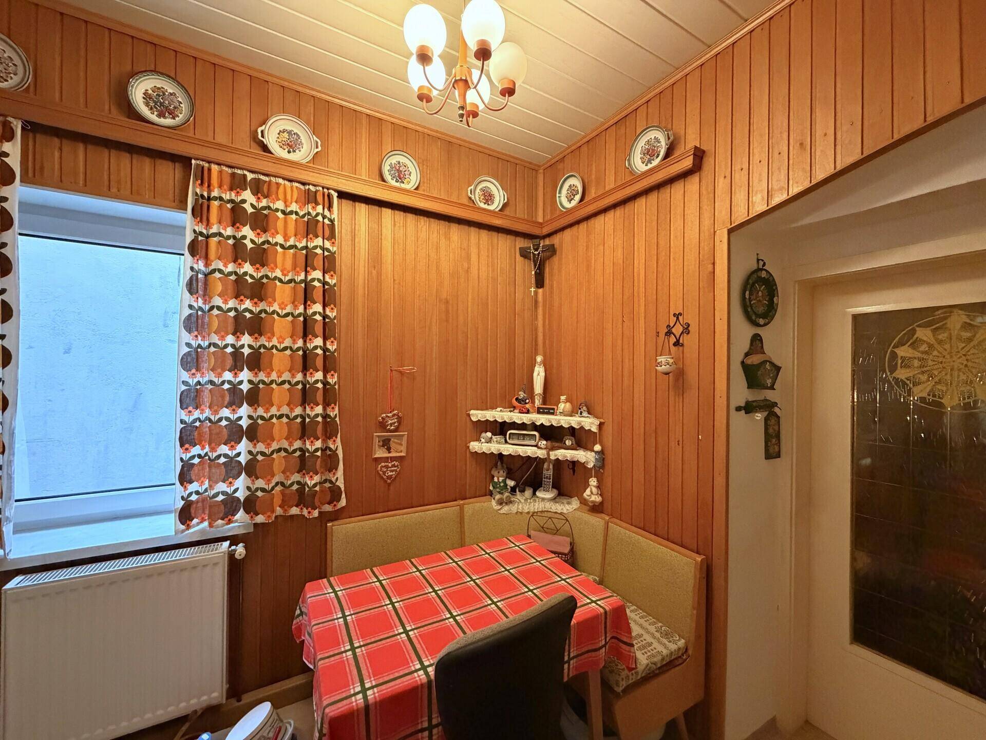 Gemütliche Essecke mit Holzvertäfelung und traditioneller Dekoration.