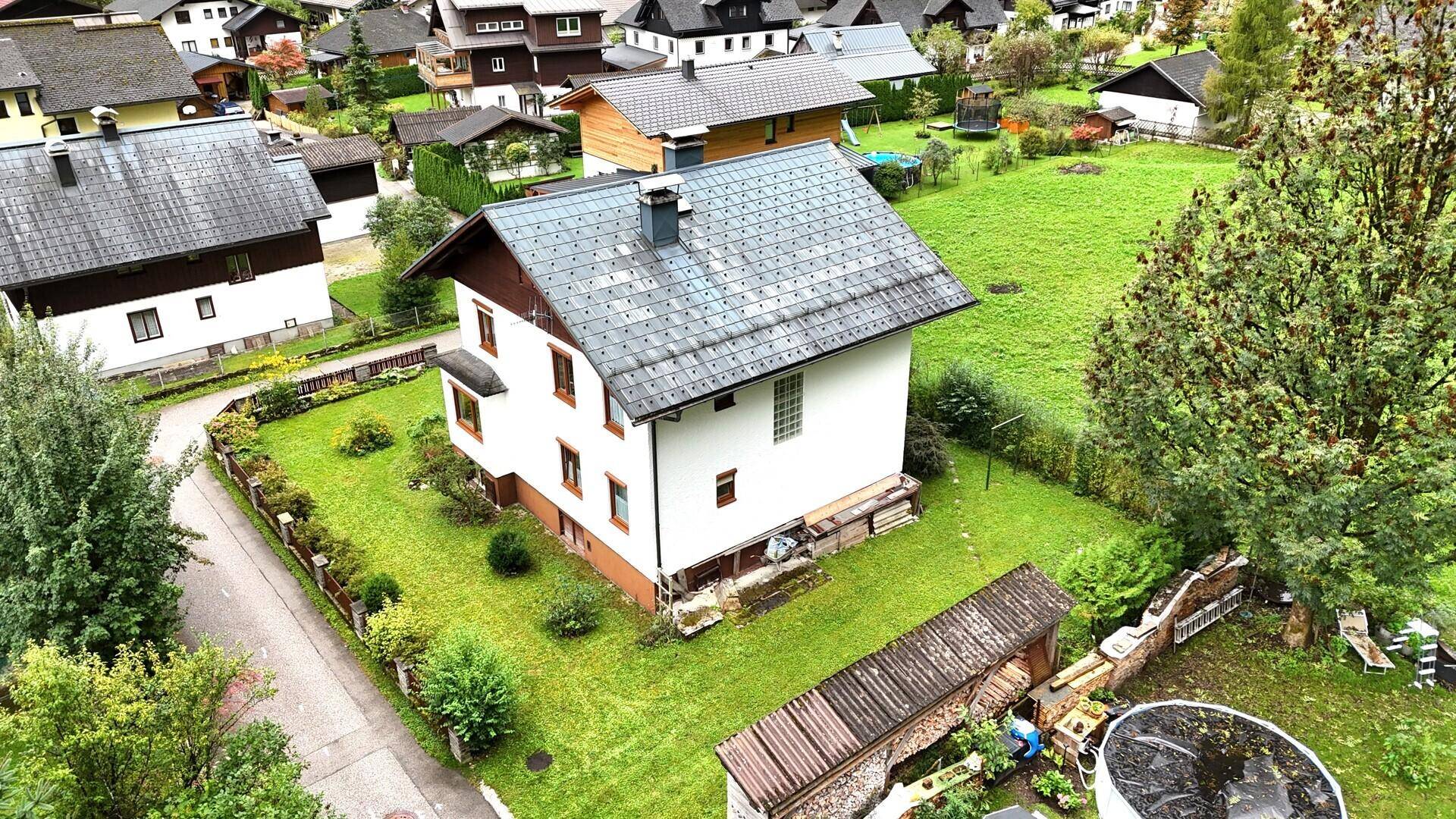 Ansicht des Einfamilienhauses von der Rückseite mit großem Gartenbereich und Nebengebäude.