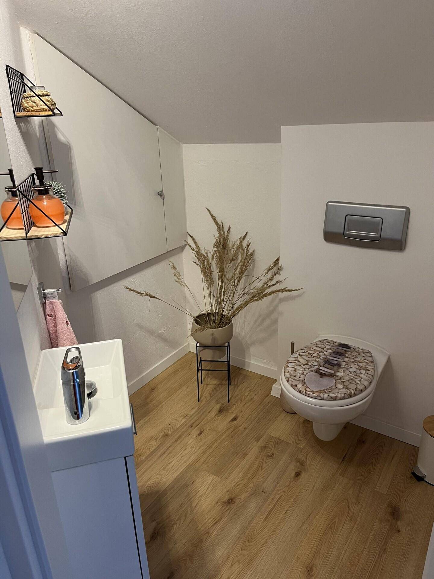 Kleines Gäste-WC mit modernem Waschtisch und Holzboden.