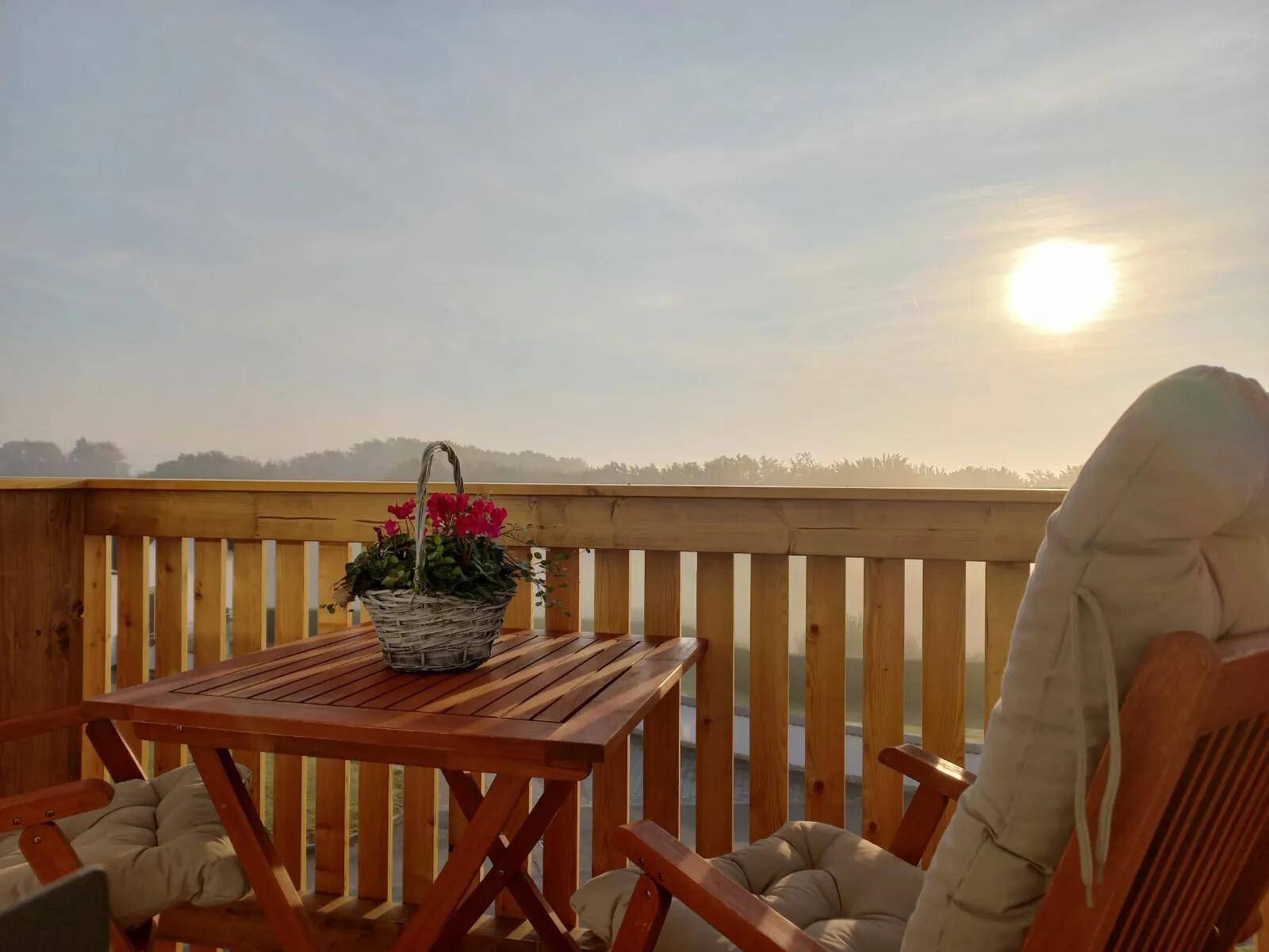 Gemütlicher Balkon mit Holztisch und Stühlen, ideal für entspannte Morgenstunden.