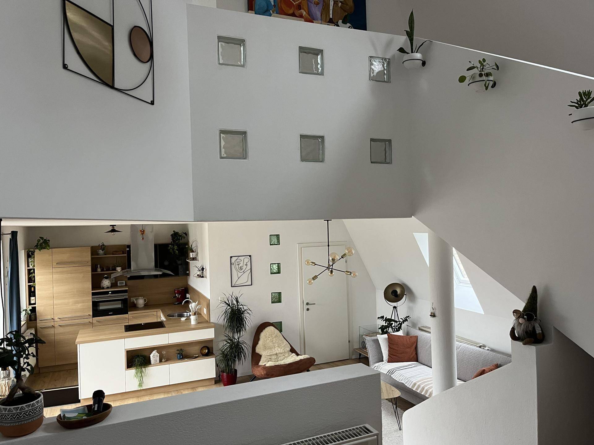 Offener Wohnbereich über zwei Ebenen mit moderner Küche und gemütlicher Sitzecke.