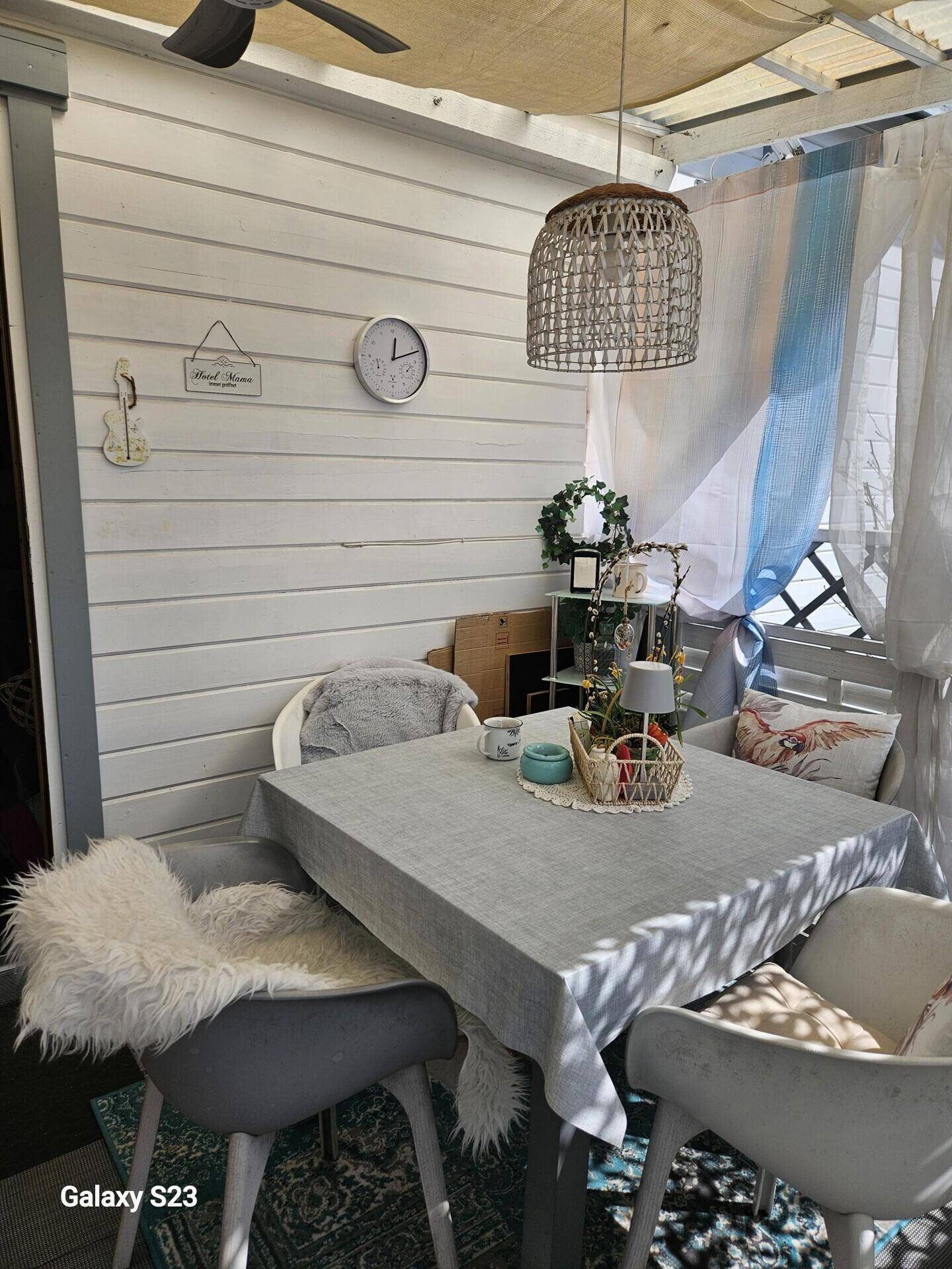 Heller, überdachter Essbereich mit Holzwänden, Deckenventilator und gemütlichen Sitzgelegenheiten.