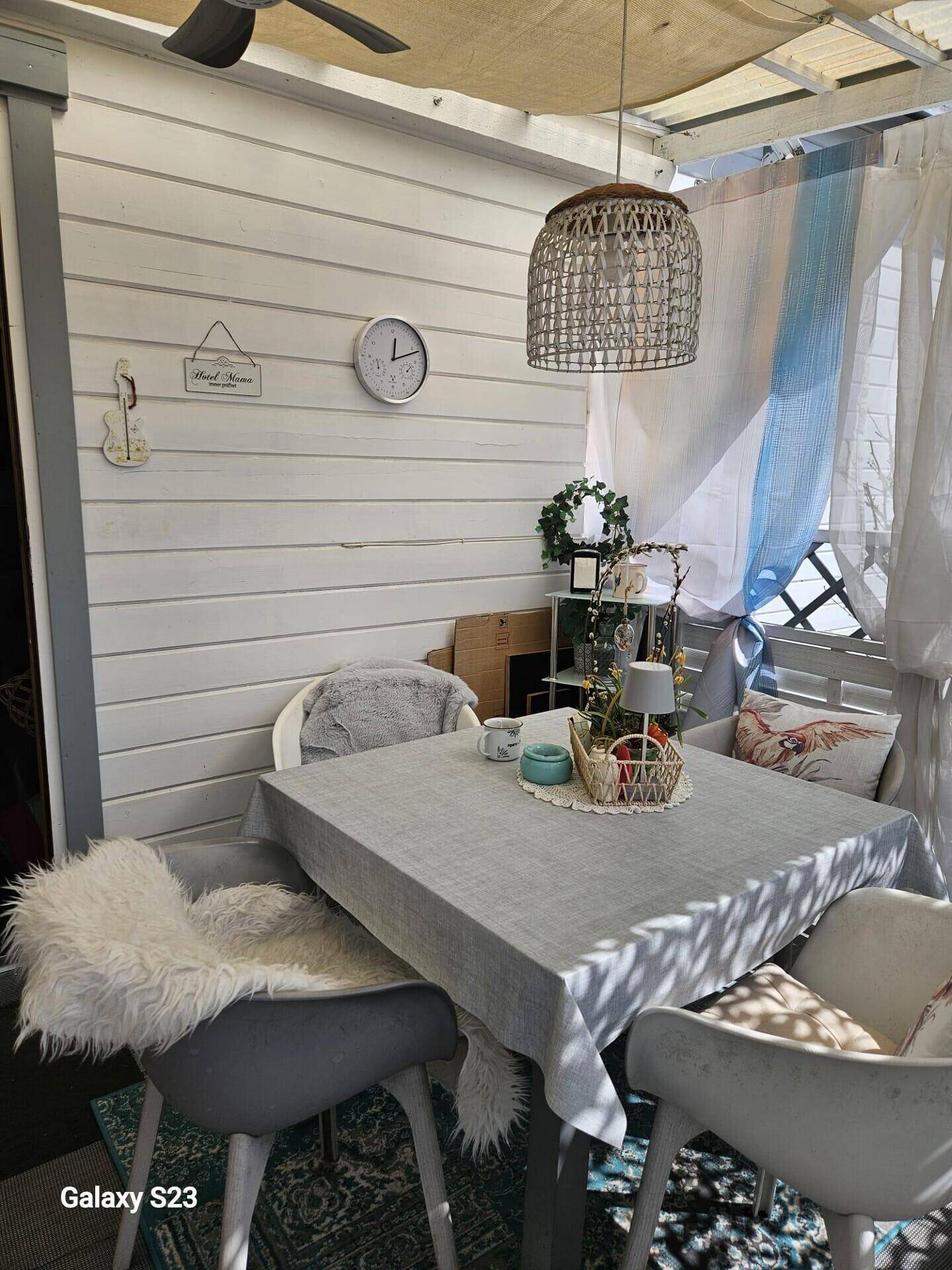 Heller, überdachter Essbereich mit Holzwänden, Deckenventilator und gemütlichen Sitzgelegenheiten.