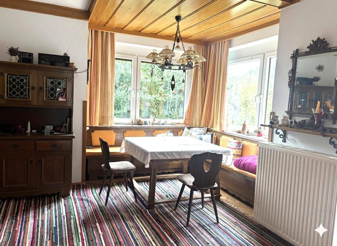 Gemütlicher Essbereich mit Eckbank, Holztäfelung an der Decke und Blick ins Grüne.