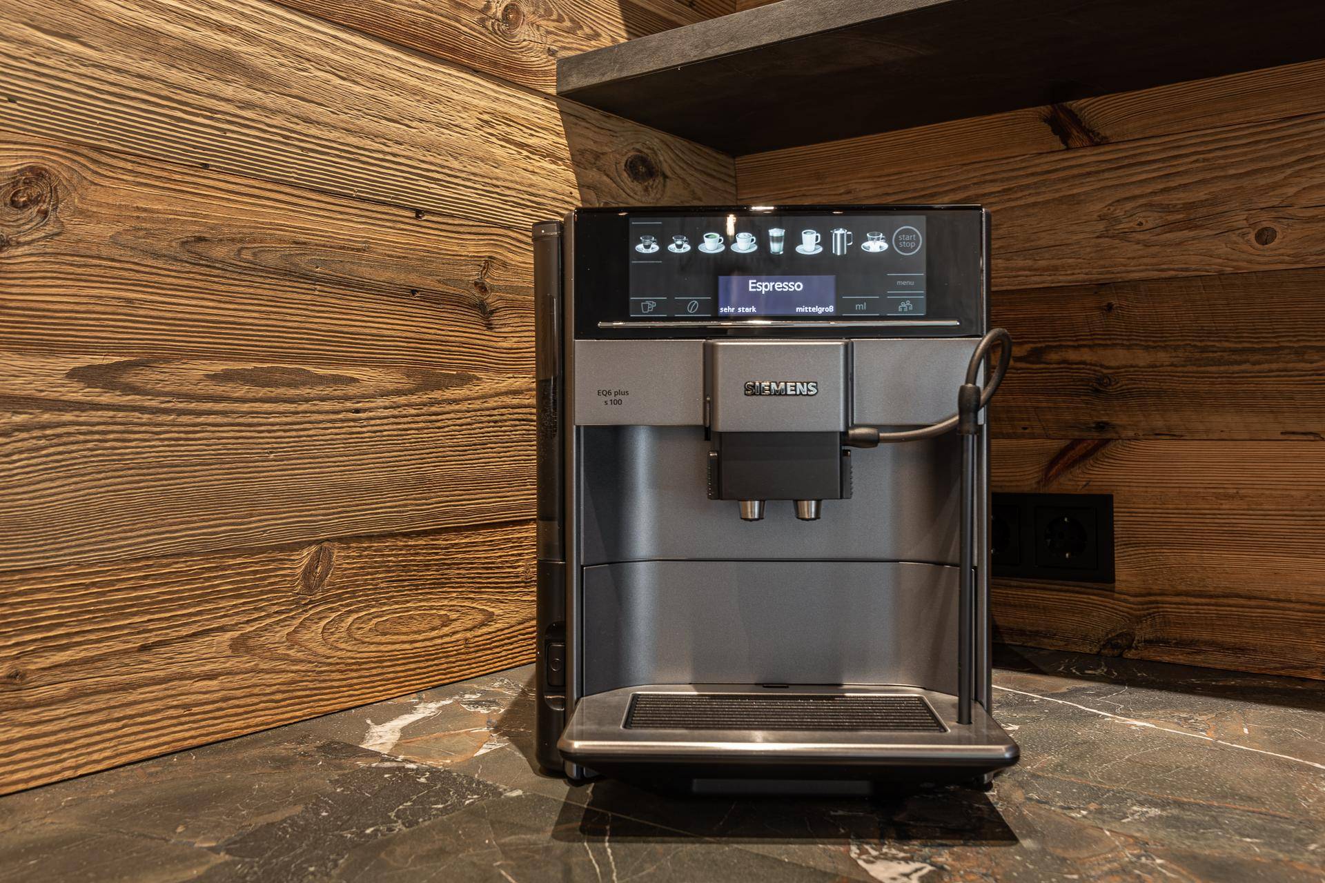 Hochwertige Kaffeemaschine auf einer dunklen Arbeitsplatte in einer modernen Küche.
