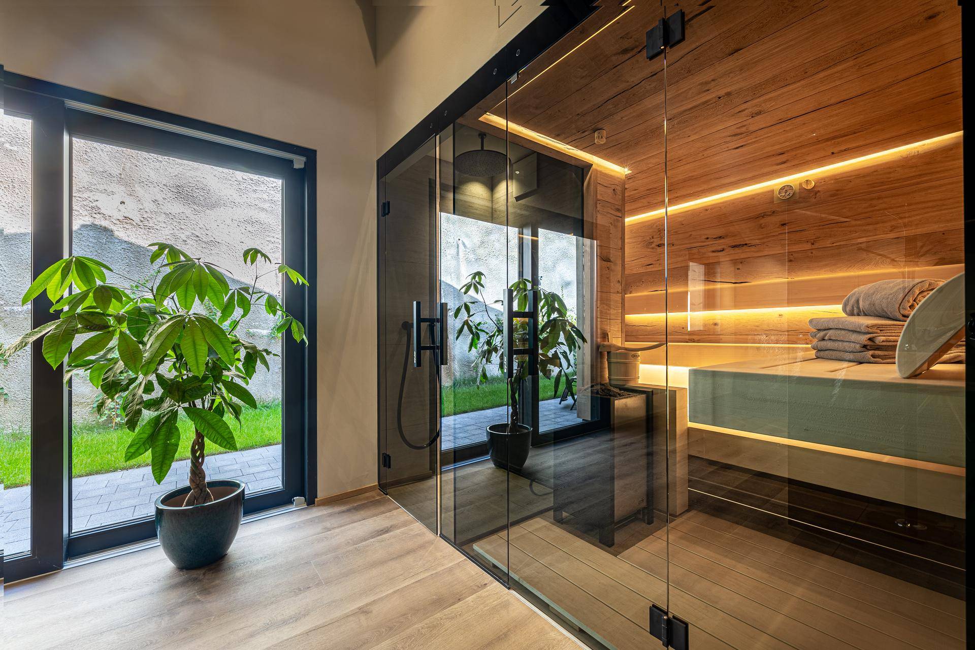 Moderner Wellnessbereich mit Sauna und Zugang zu einem kleinen Außenbereich.