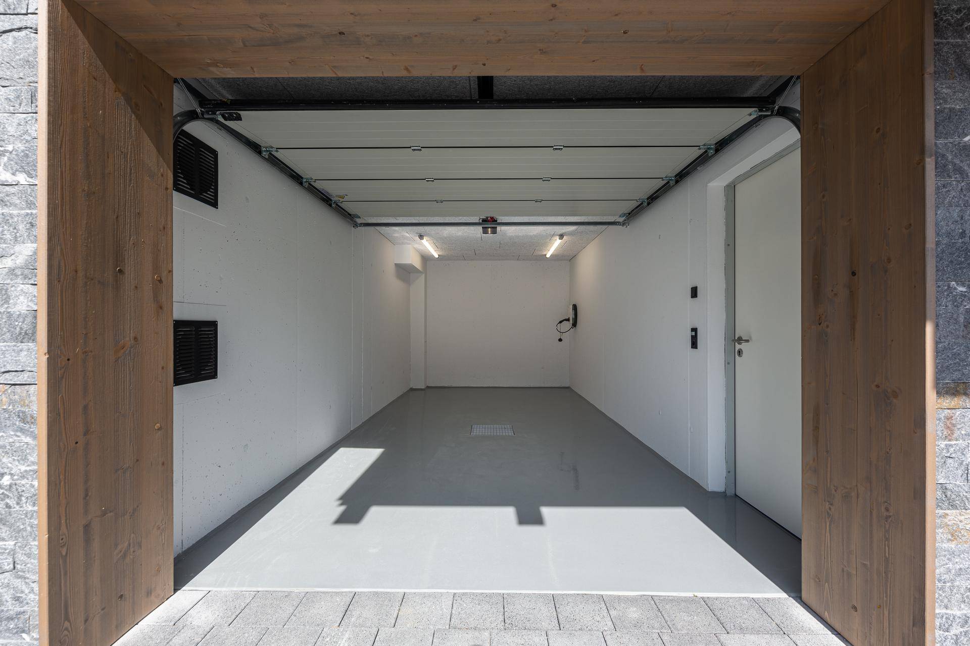 Geräumige Garage mit sauberem Boden und Platz für ein Fahrzeug.