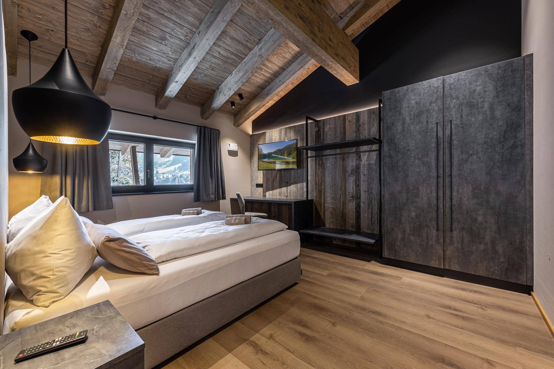 Modernes Schlafzimmer mit Holzbalkendecke, Holzboden und integriertem Kleiderschrank.