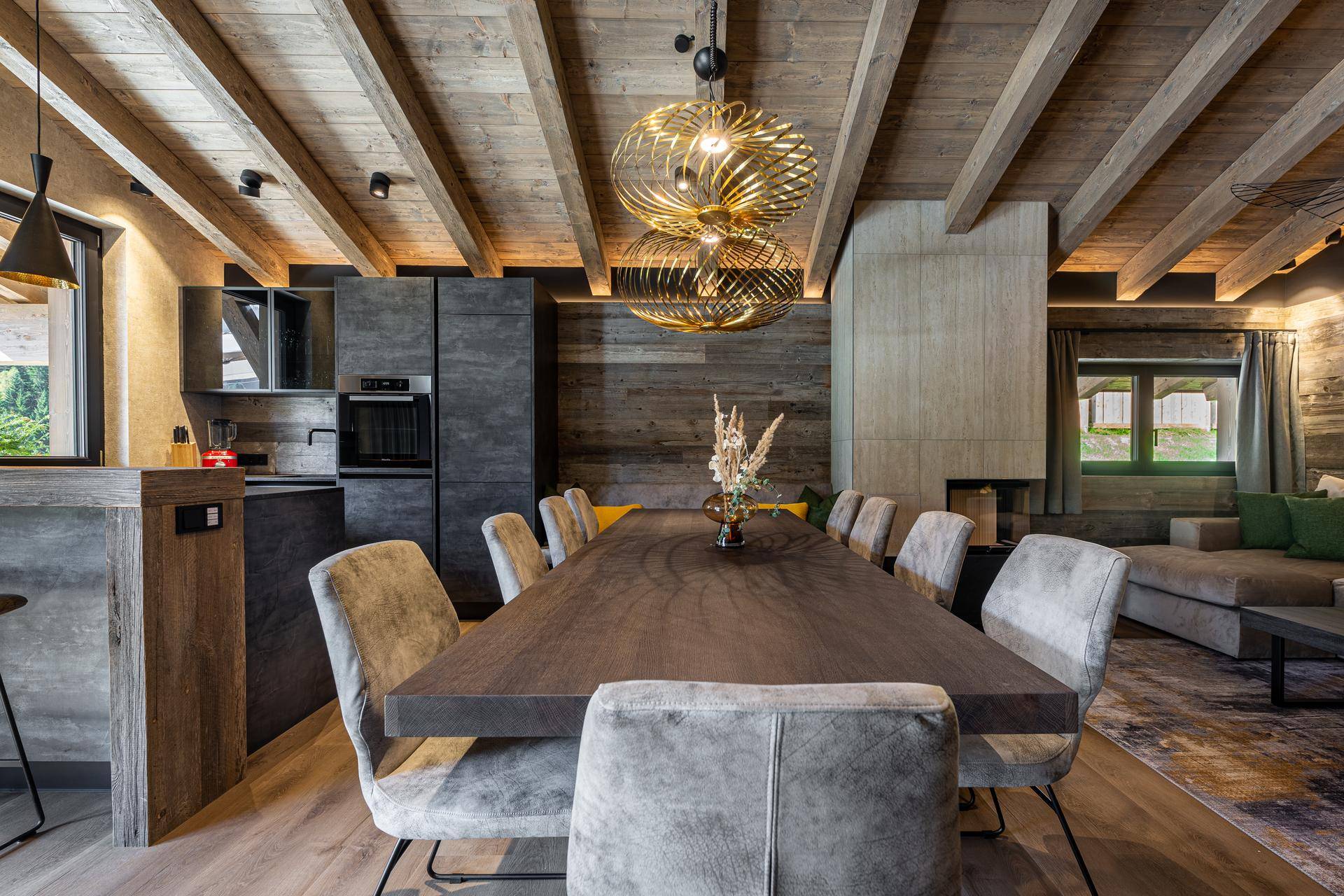 Eleganter Essbereich mit langem Holztisch, bequemen Stühlen und Blick auf die offene Küche.