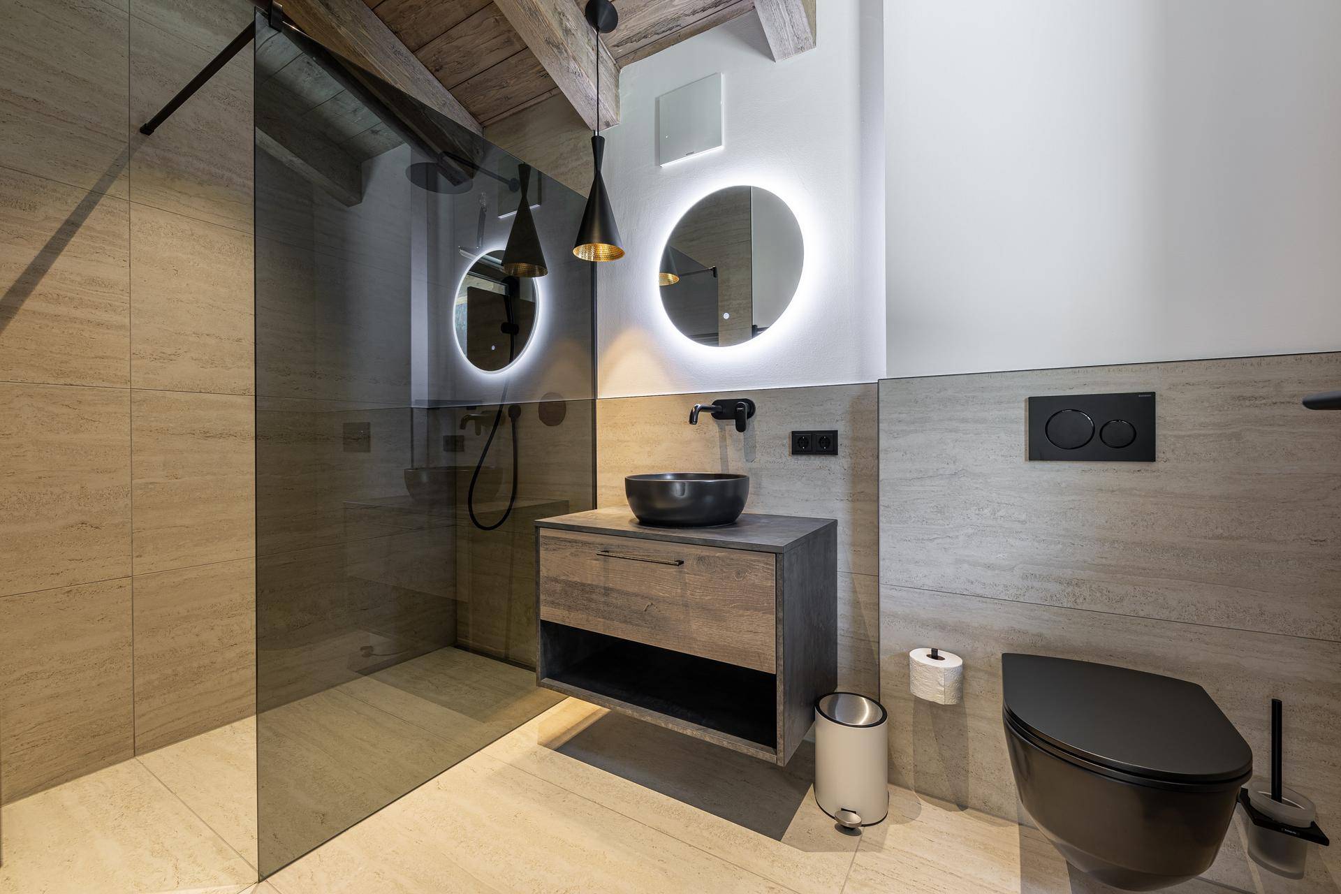 Modernes Badezimmer mit begehbarer Dusche, runden Spiegeln und stilvollen schwarzen Armaturen.