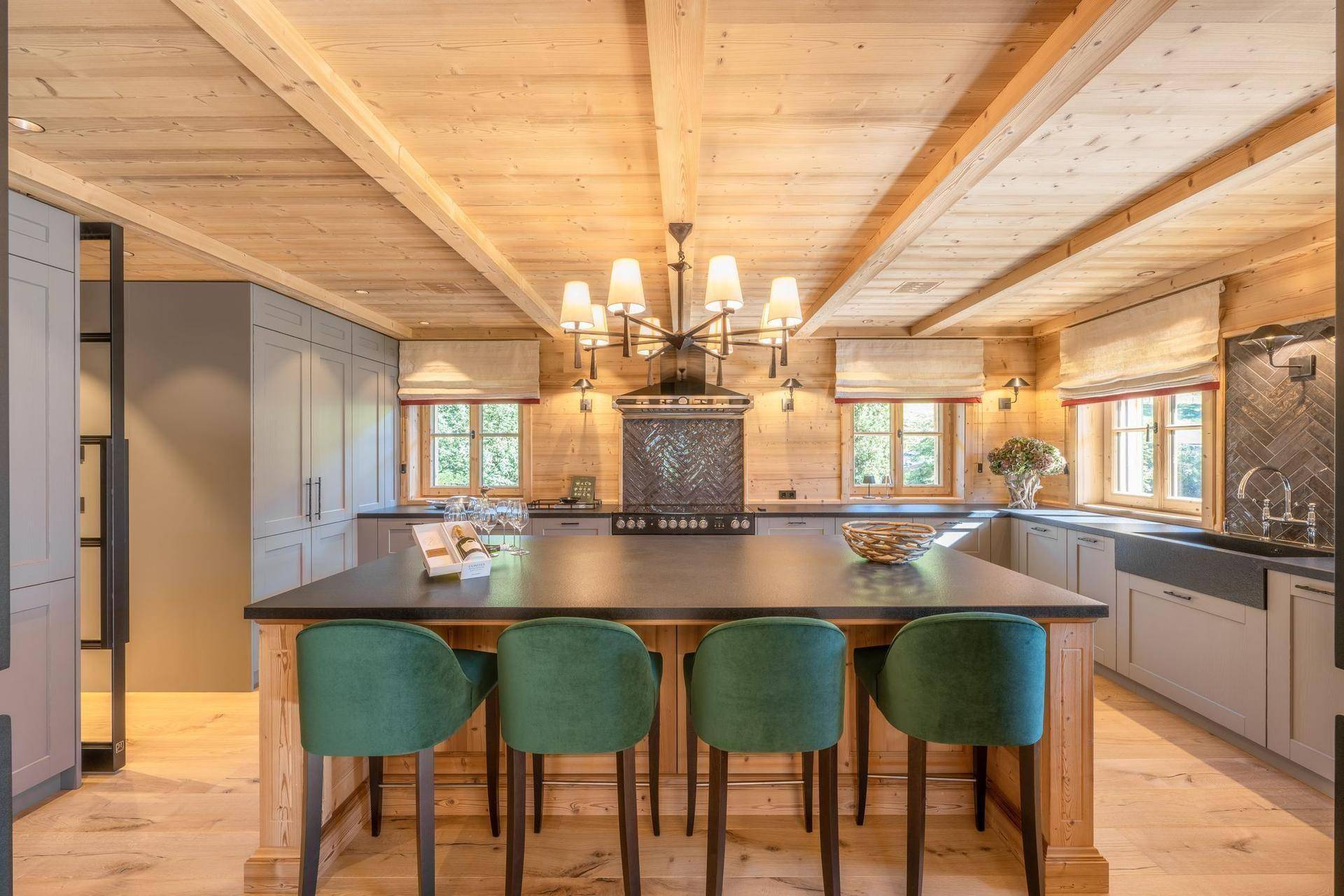 Moderne Küche mit Holzdecke, großer Kochinsel und hochwertigen Geräten im Landhausstil.