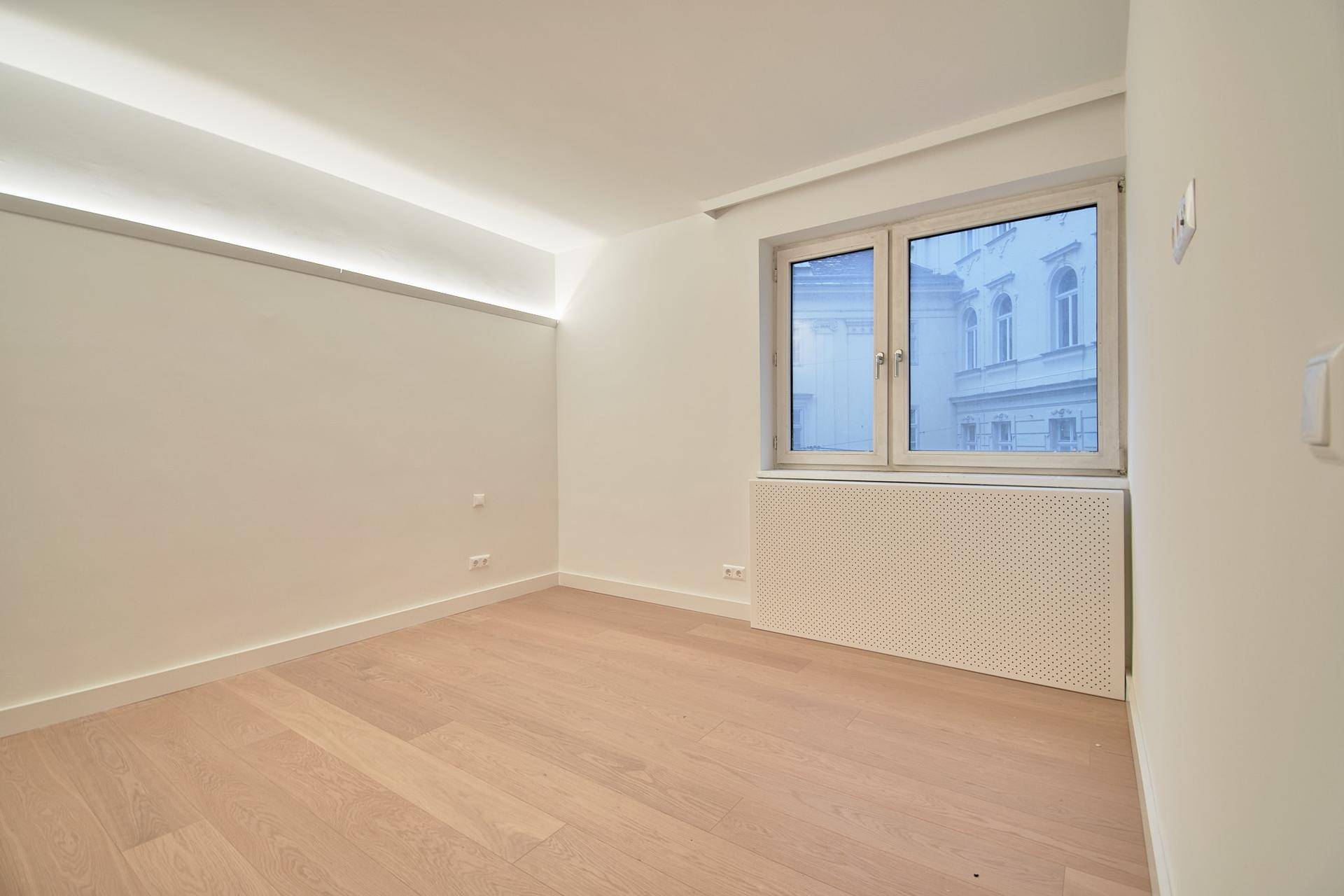 Heller Raum mit großem Fenster und Holzboden, bietet viel natürliches Licht.
