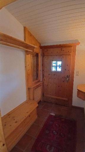 Eingangsbereich mit Holztür, Garderobe und Fliesenboden im traditionellen Stil.