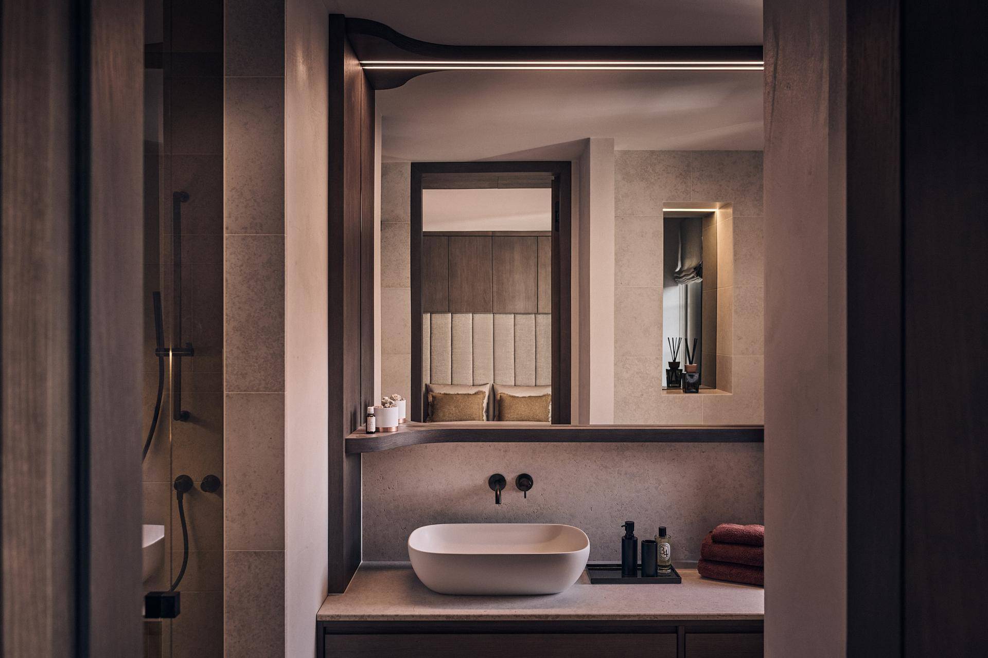 Stilvolles Badezimmer mit modernem Waschbecken, indirekter Beleuchtung und Holzakzenten.