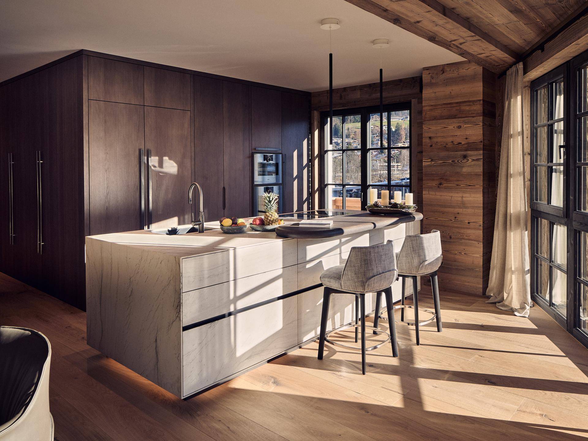 Moderne Küche mit Kücheninsel, Holzboden und viel Tageslicht, ideal für gesellige Kochabende.